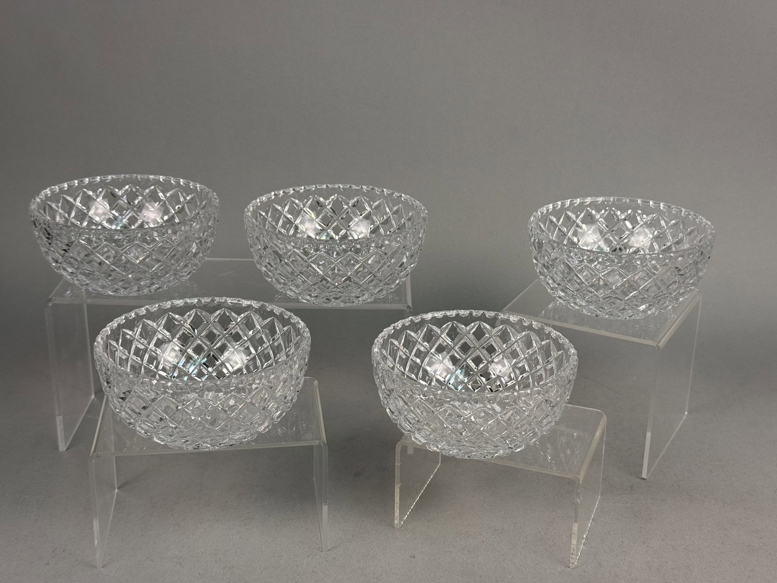 Set of Five Cut Crystal Bowls: A set of five lead crystal dessert bowls featuring a deep diamond lattice cut pattern. The bowls are finished with serrated scalloped rims and multi-point radial starburst cuts to the underside of the