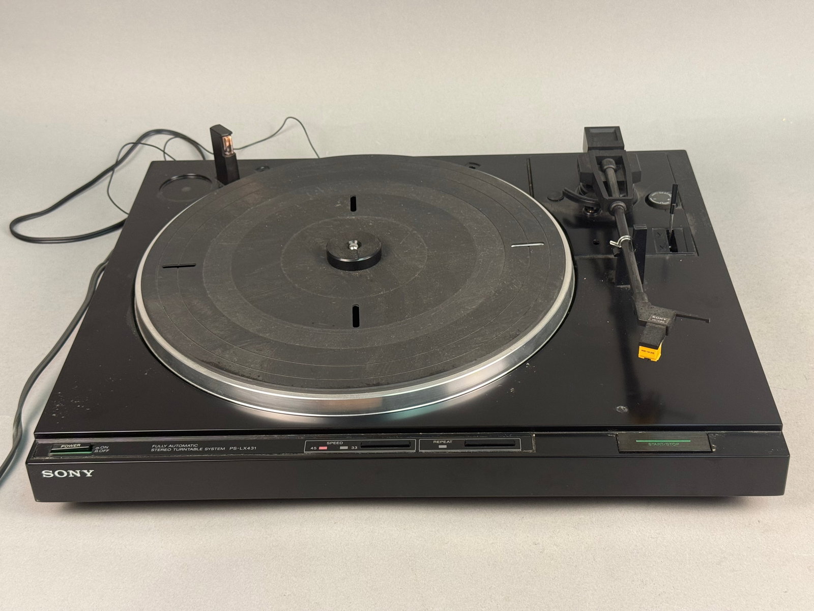 Sony Plastic Automatic Stereo Turntable: A vintage Sony PS-LX431 fully automatic stereo turntable system manufactured in Japan. The unit features a black molded plastic housing, a circular aluminum platter, and a black rubber slip mat. The