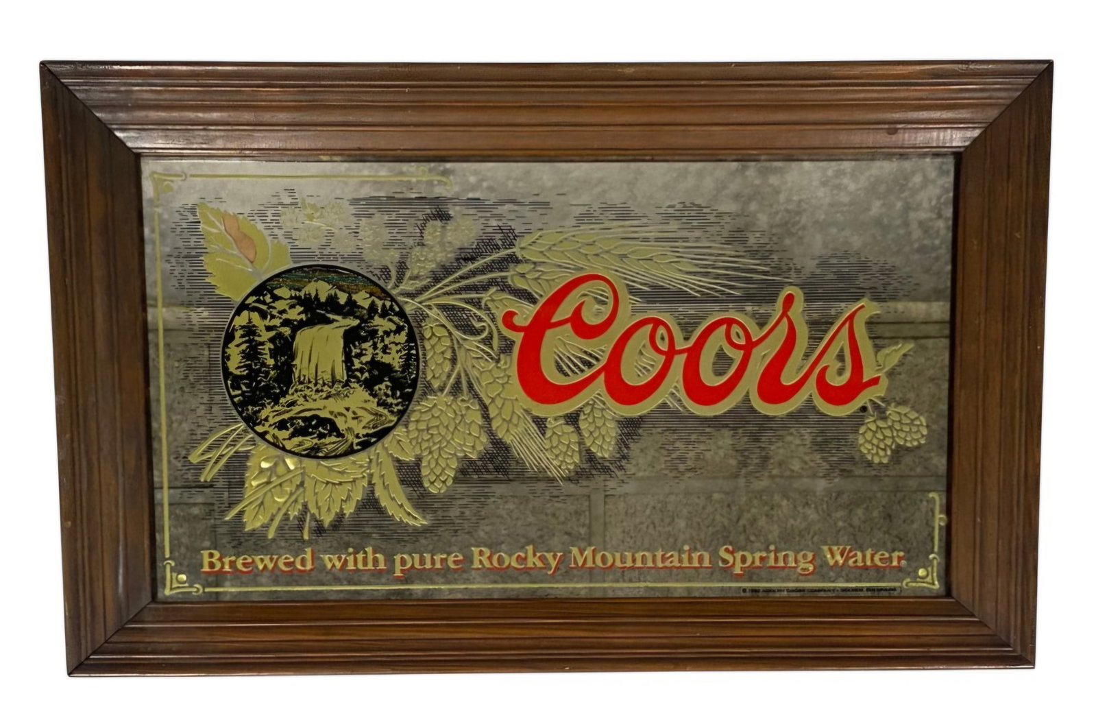 Vintage 1980 Coors Advertising Mirror: This 1980 Coors Brewing Company advertising mirror features the iconic script logo and a circular waterfall vignette. The screen-printed glass is decorated with metallic gold hop cones and stalks alon