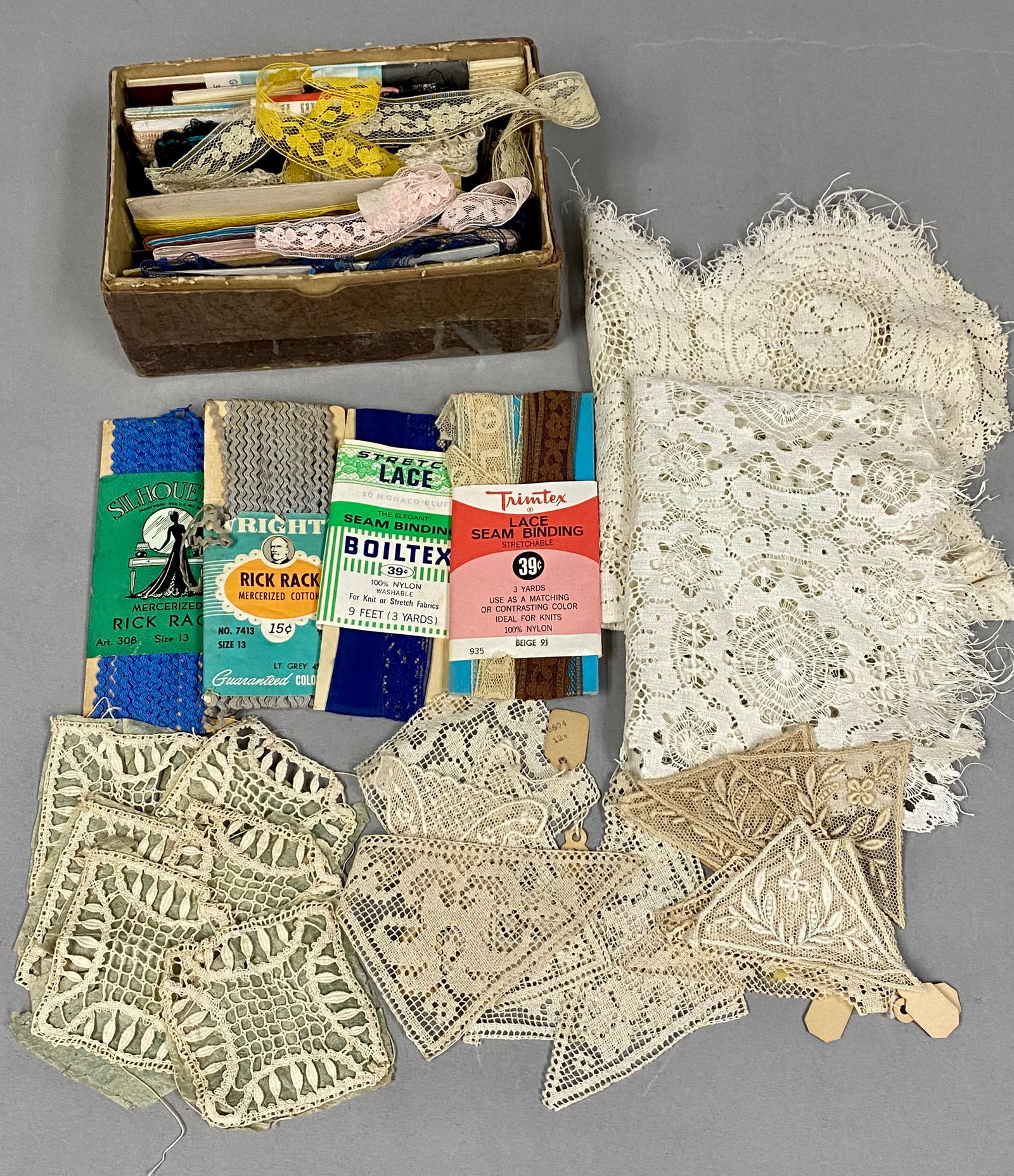Vintage Lace and Sewing Trim Collection: This collection includes an assortment of mid-20th-century sewing notions featuring carded rick rack from Wright's and Silhouette alongside stretch lace seam binding by Boiltex and Trimtex. The lot co