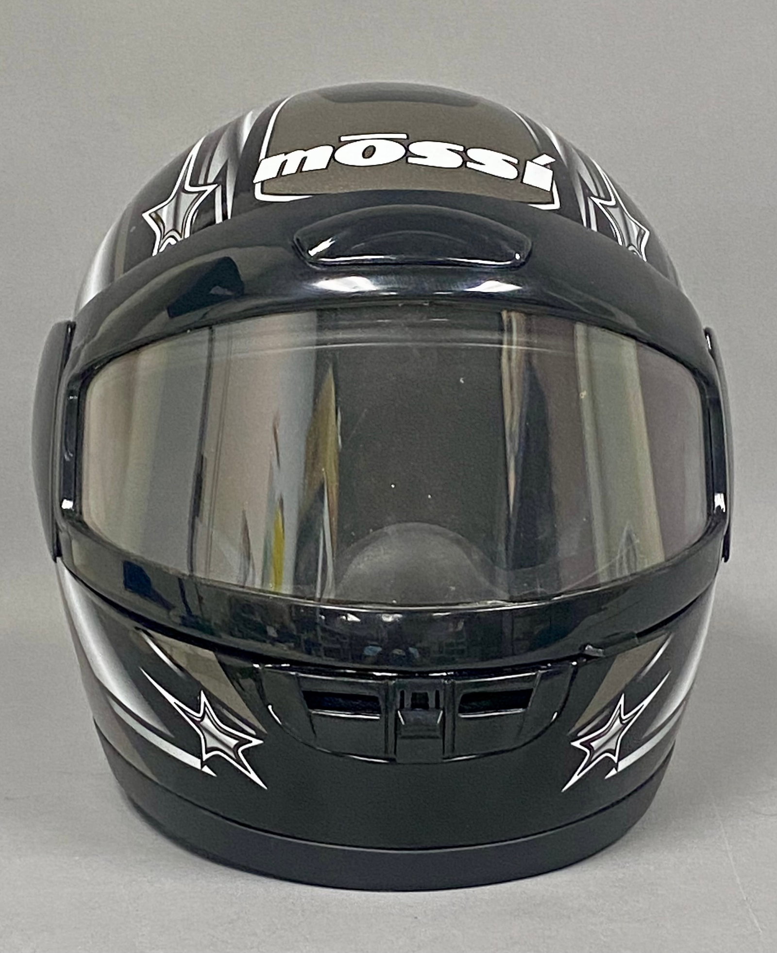 Mossi A-632 Full Face Motorcycle Helmet: This Mossi A-632 full-face motorcycle helmet features a gloss black shell decorated with silver and white star graphics. Produced by Queen Kwan Enterprise Co., Ltd., the unit is equipped with a clear 