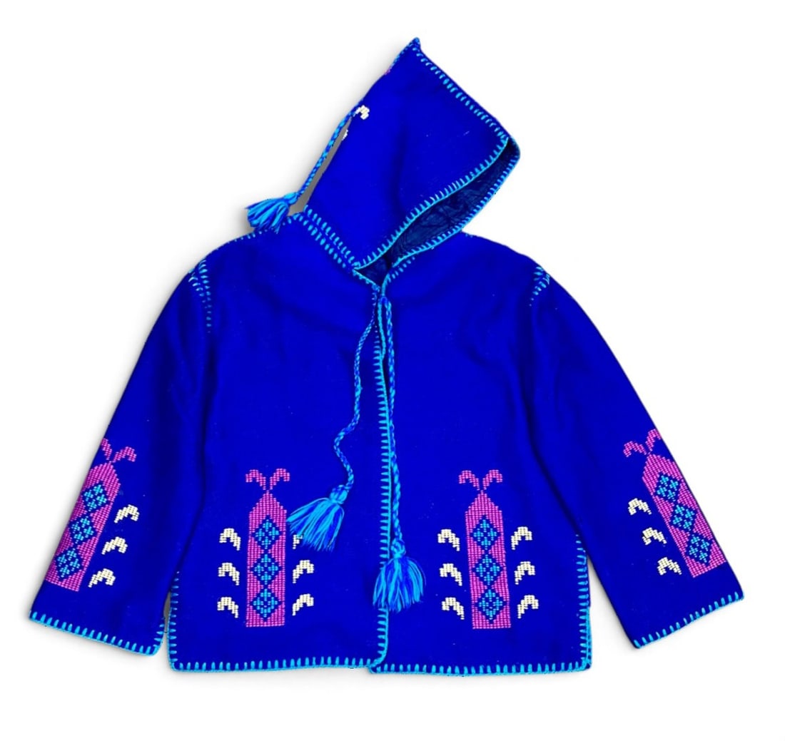 Vintage Moroccan Style Embroidered Wool Jacket: This royal blue wool-blend jacket features traditional Moroccan-style construction with a pointed hood and braided tassels. The garment is embellished with magenta and turquoise geometric