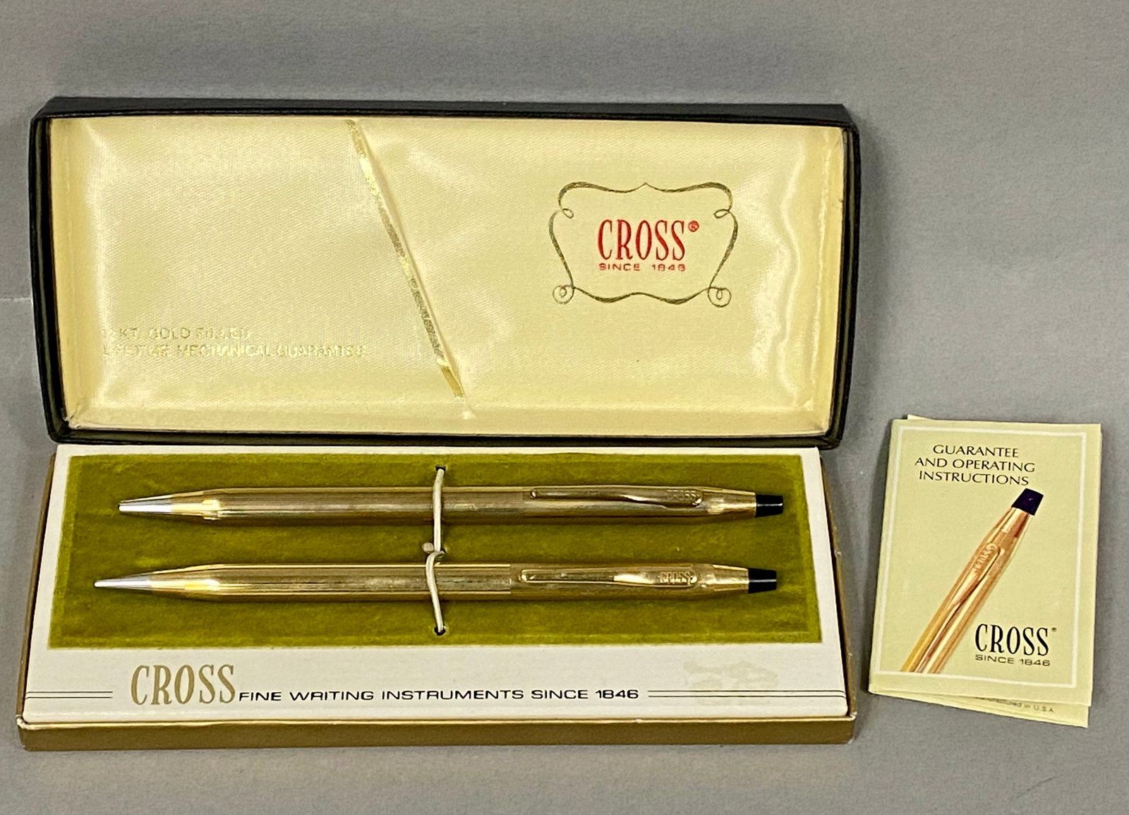 Cross 12kt Gold Filled Pen Set: This vintage Cross writing set, model 6601, includes a ballpoint pen and a mechanical pencil. Both instruments are constructed from 12kt gold-filled metal with an incised vertical pinstripe pattern