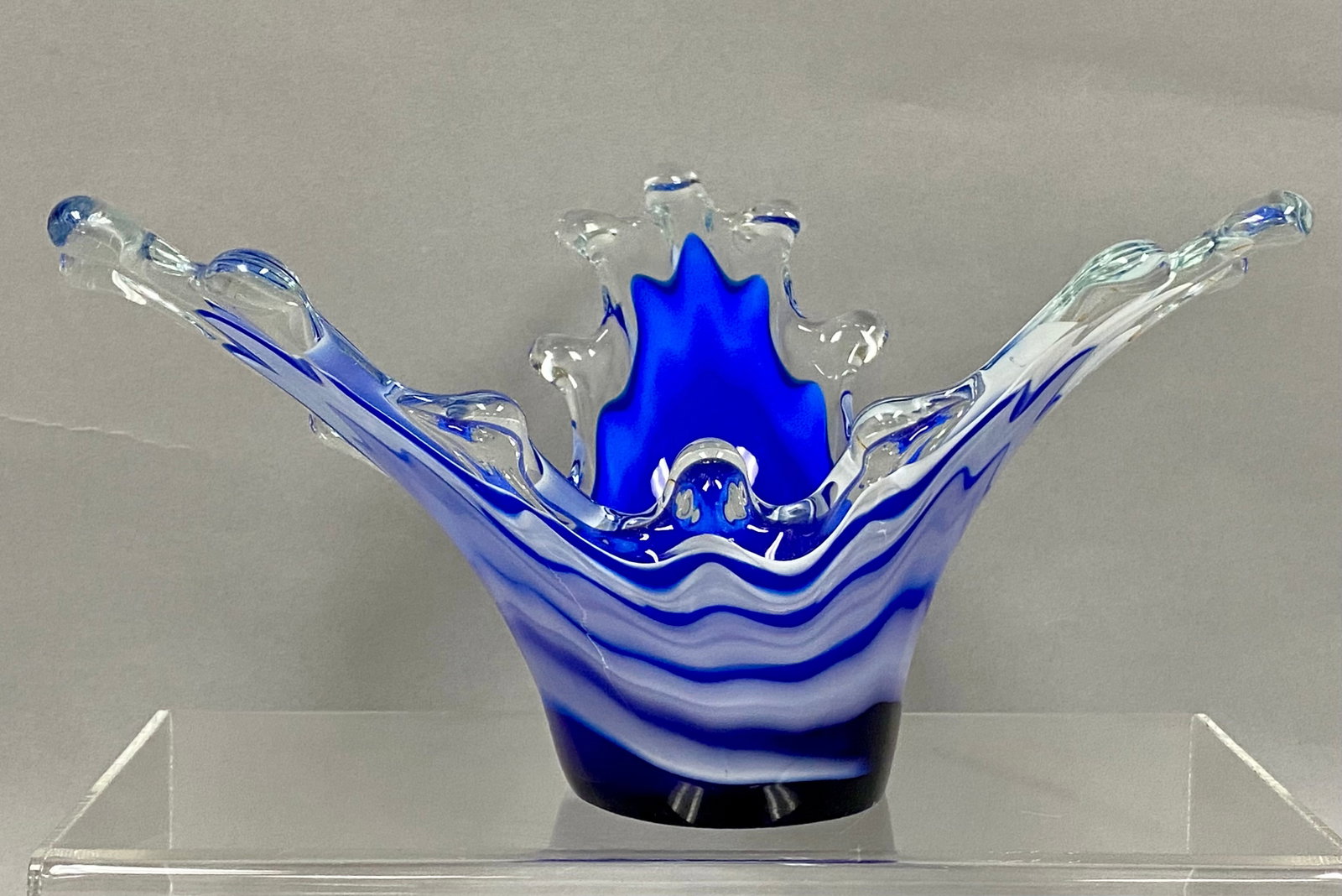 Kirch Ukrainian Art Glass Splash Bowl: A hand-blown art glass centerpiece bowl featuring a dynamic splash form with multiple pulled points. The vessel is constructed with layered cobalt blue and opaque white glass encased in a thick clear