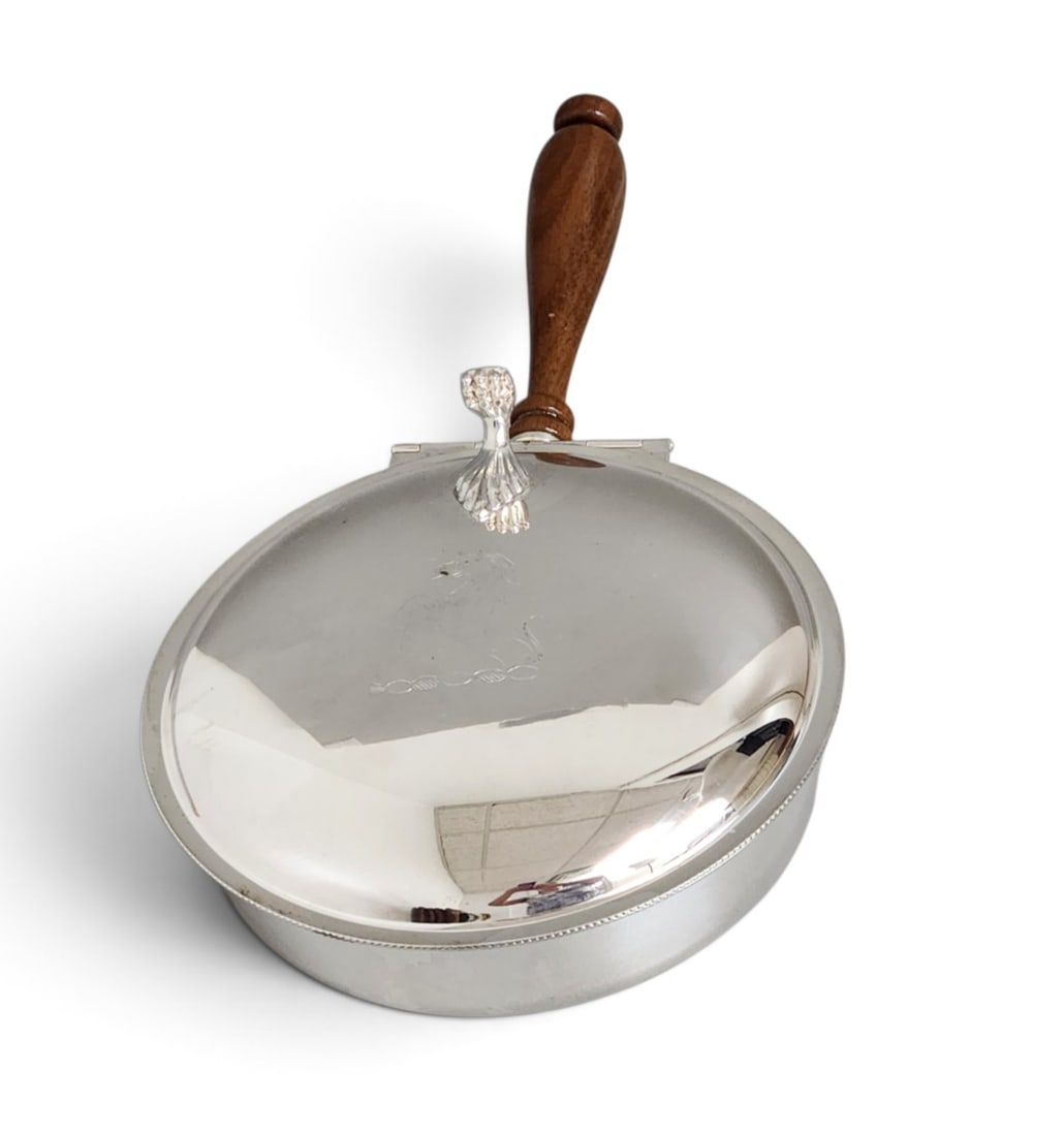 Sheffield Silver Co. Silent Butler: A silver-plated silent butler manufactured by the Sheffield Silver Co. featuring a circular hinged lid engraved with a heraldic horse crest. The piece is fitted with a turned wooden handle and a