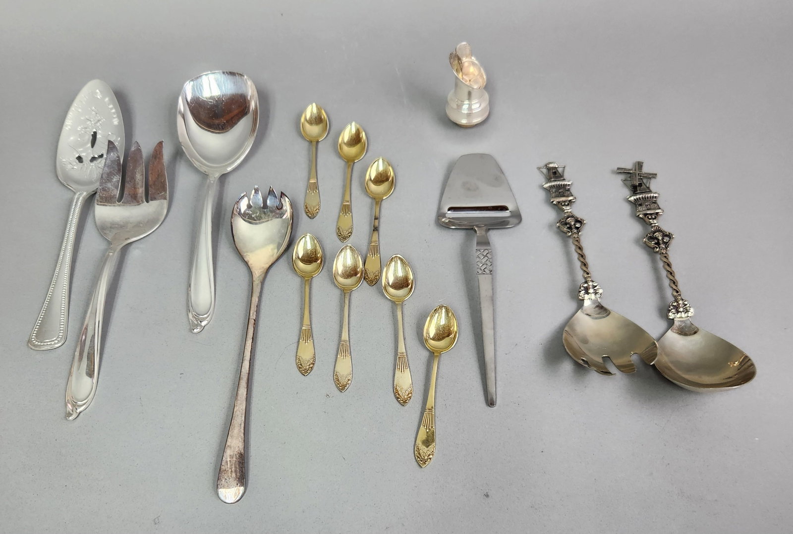 Decorative Silver Plate Serving Pieces: An assortment of silver-toned and gold-toned serving pieces featuring various decorative motifs and functional designs. Pieces were not inspected. Large serving pieces: 8 to 9 inches long Small gold-t