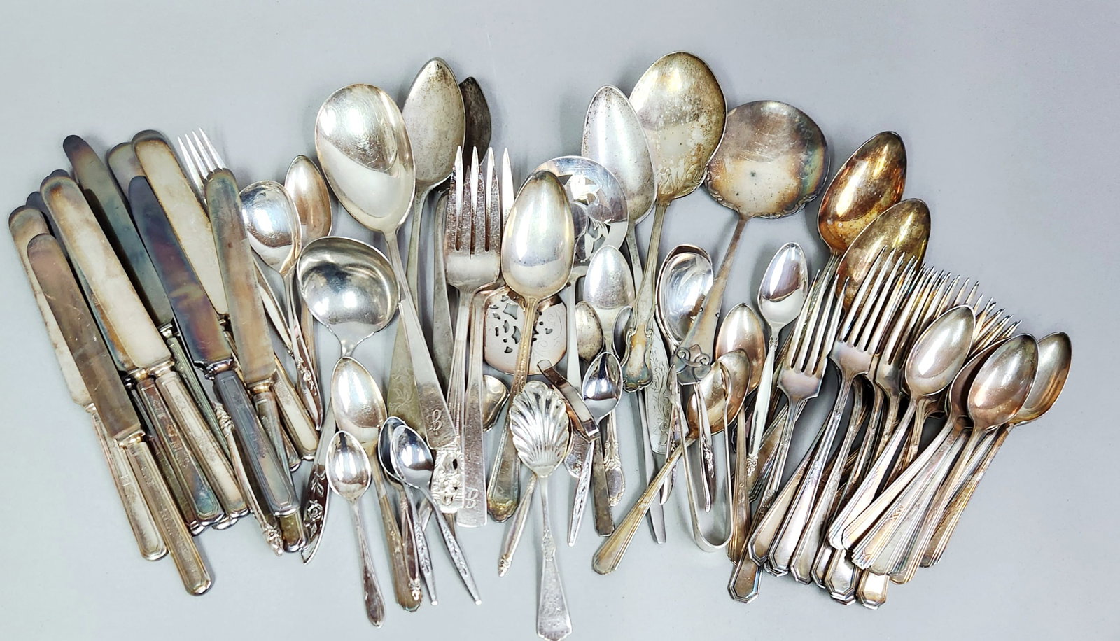 Assorted Vintage Silver-Plated Flatware: Contents not inspected. All pieces exhibit heavy tarnish and oxidation, ranging from iridescent patinas to deep black spotting. Surface scratches, minor scuffs, and signs of moderate wear consistent