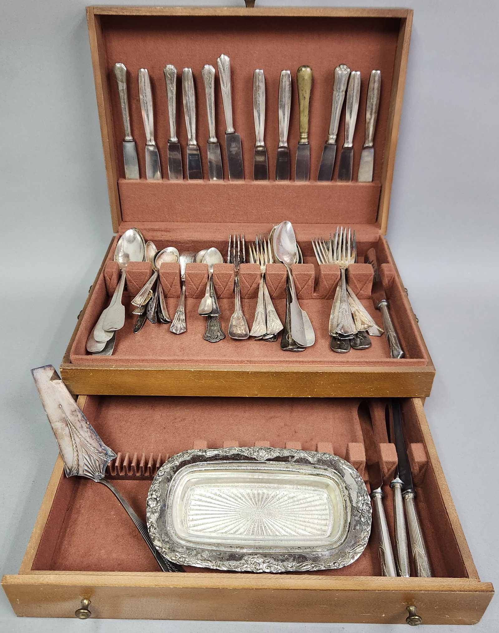 Silver-Plated Flatware & Chest: Contents not inspected. Chest: 16 W x 12 D x 6 H inches The flatware exhibits significant tarnish throughout, and one knife handle displays prominent yellowing. The wooden chest shows surface