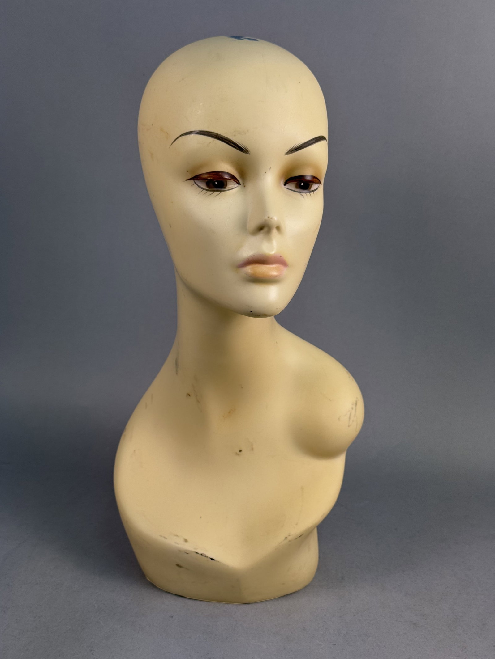 NJS Vinyl Stylized Mannequin Bust: A vintage mid-century modern mannequin display bust, produced for retail millinery or wig presentation. The piece is constructed from molded synthetic vinyl with a matte finish and features a highly