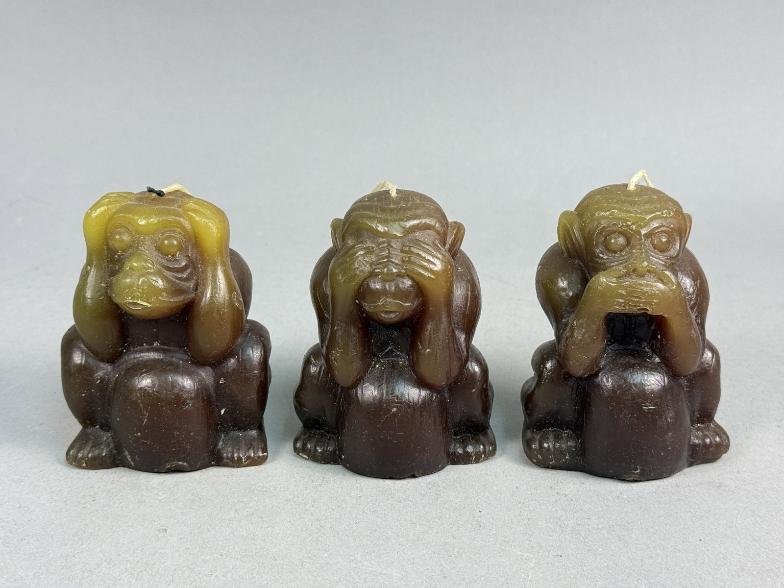 Japanese Wax Wise Monkey Novelty Candles: A set of three Japanese novelty candles depicting the Three Wise Monkeys motif. The figures represent See No Evil, Hear No Evil, and Speak No Evil, each molded in a seated, hunched posture. The candle