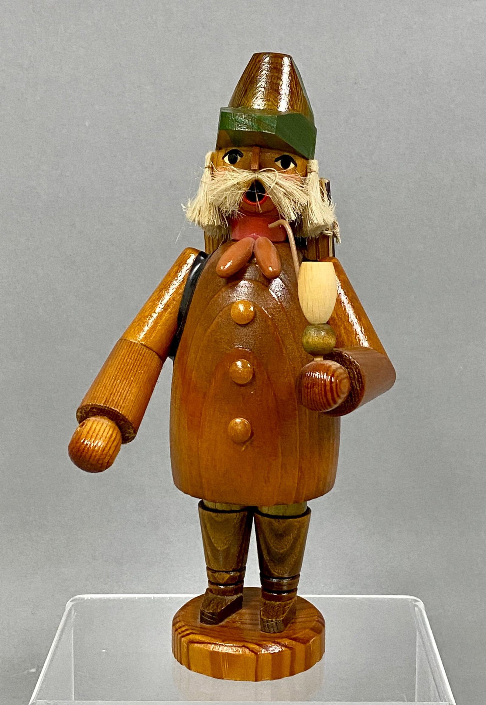 KWO Erzgebirge Woodman Incense Smoker: A KWO Erzgebirge wooden incense smoker depicting a woodman carrying a backpack of logs and a jug. The figure is constructed from stained and painted turned wood with a fiber beard and a metal