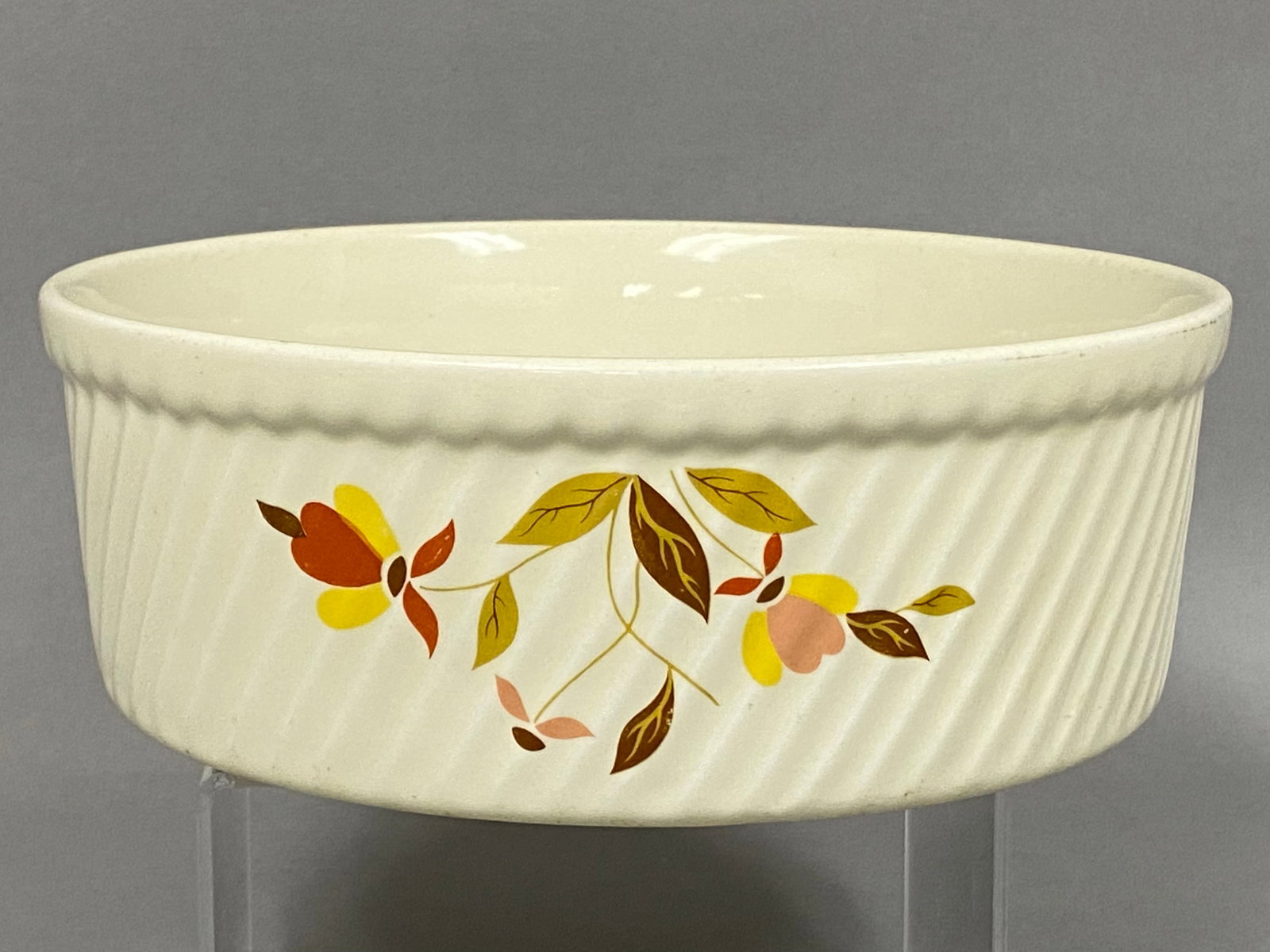 Hall Autumn Leaf Jewel Tea Bowl: This Hall China Company ceramic bowl features the Autumn Leaf pattern produced for the Jewel Tea Company. The round vessel is designed with a cream-colored high-gloss glaze, a vertically fluted