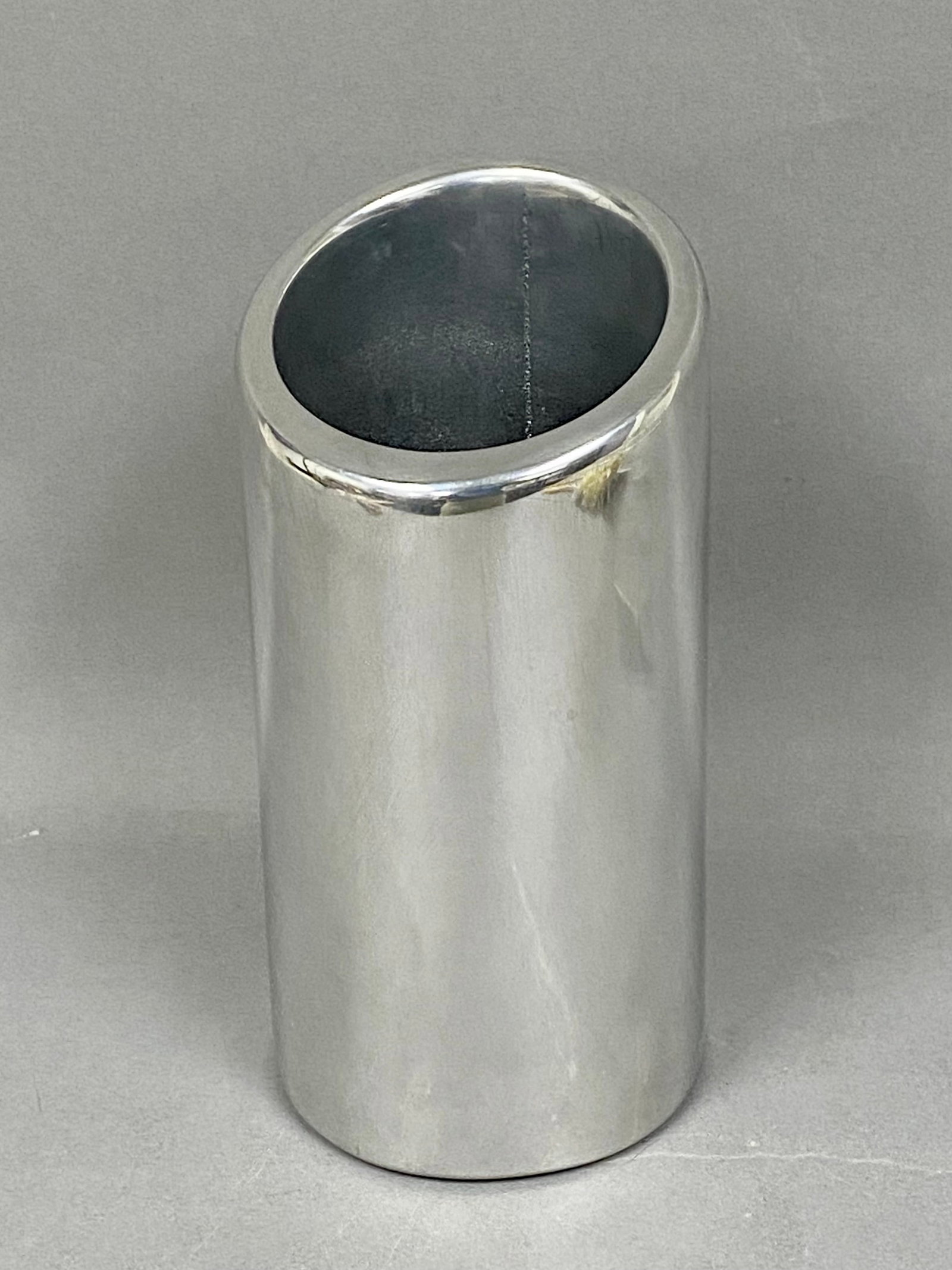Nambe Tilt Wine Chiller 541: This Nambe Tilt wine chiller, part number 541 XX, is manufactured from a sand-cast metal alloy with a high-luster polished finish. The piece features a minimalist cylindrical form with a distinct