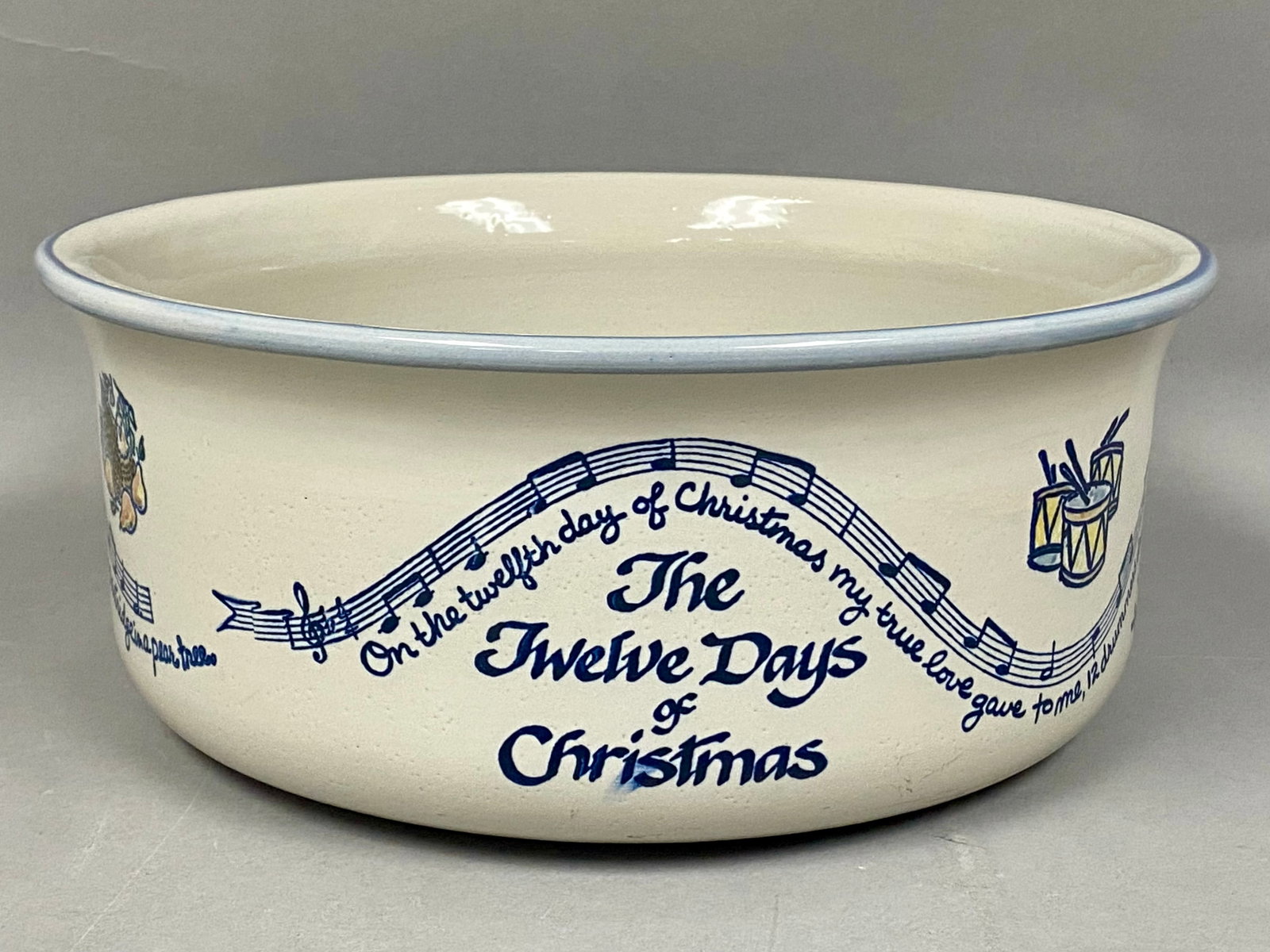 Louisville Stoneware Twelve Days Christmas Bowl: A large stoneware punch bowl by Louisville Stoneware featuring the Twelve Days of Christmas pattern. The exterior displays hand-painted musical staves and lyrics interspersed with illustrations of the
