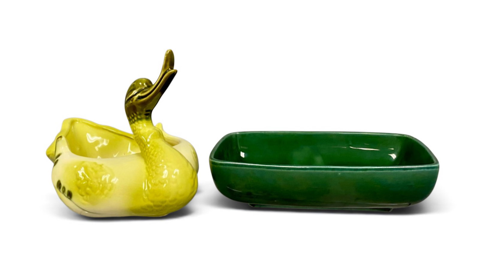 Two American Glazed Ceramic Planters: This lot features a Hull Pottery figural swan planter and a low rectangular earthenware planter. The swan is decorated with a two-tone yellow and green glossy glaze and features molded relief details
