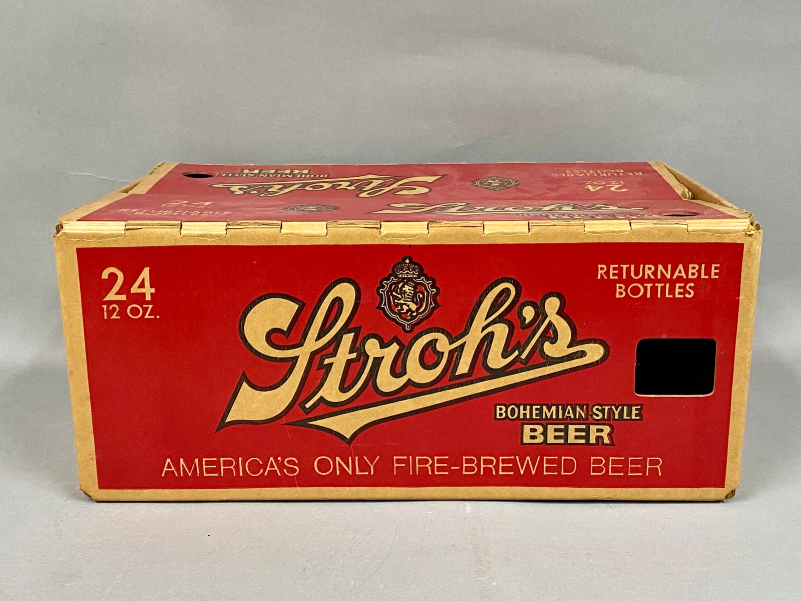 Vintage Stroh's Beer 24-Bottle Case: A vintage Stroh's Bohemian Style Beer cardboard case constructed from red-printed Concora Coated corrugated fiberboard. The exterior displays the brewery's script logo and promotional text for America