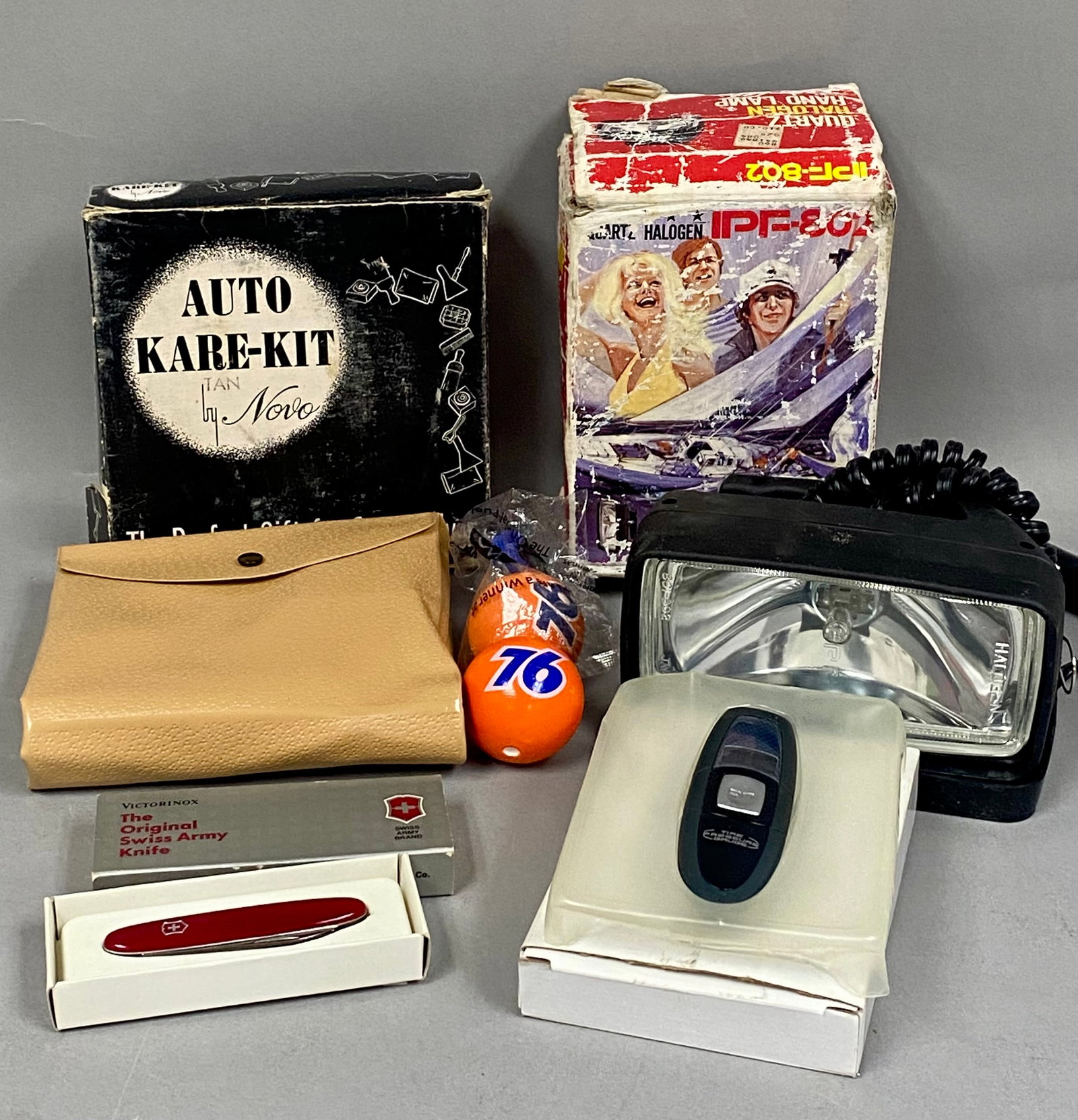 Vintage IPF & Novo Automotive Accessories & Victorinox Knife: An assortment of vintage automotive accessories and collectibles. The collection includes a Japanese-made IPF-802 Quartz Halogen hand-held spotlight featuring a black plastic housing with a pistol gri