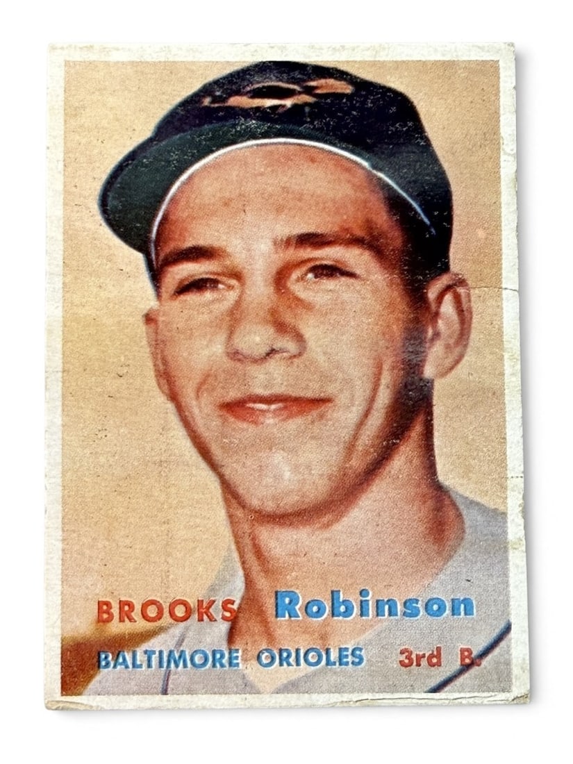 1957 Topps Brooks Robinson Rookie Baseball Card: A vintage 1957 Topps baseball card featuring Baltimore Orioles third baseman Brooks Robinson, identified as card number 328. This rookie card displays a color portrait photograph of Robinson with his 