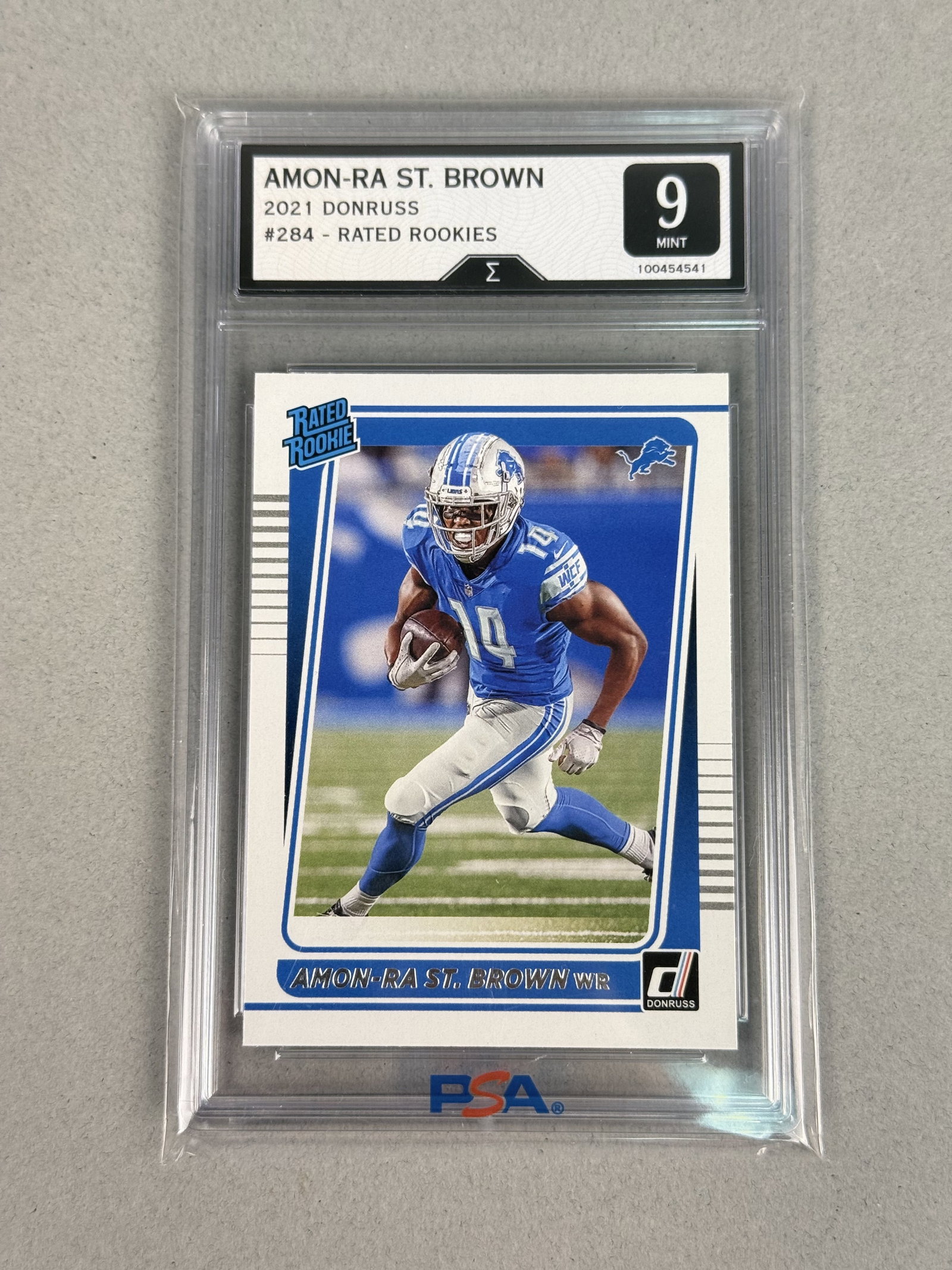 2021 Donruss Amon-Ra St. Brown Sigma 9: This 2021 Panini Donruss football card features Detroit Lions wide receiver Amon-Ra St. Brown. Identified as card number 284 from the popular Rated Rookie subset, the card is encapsulated in a profess