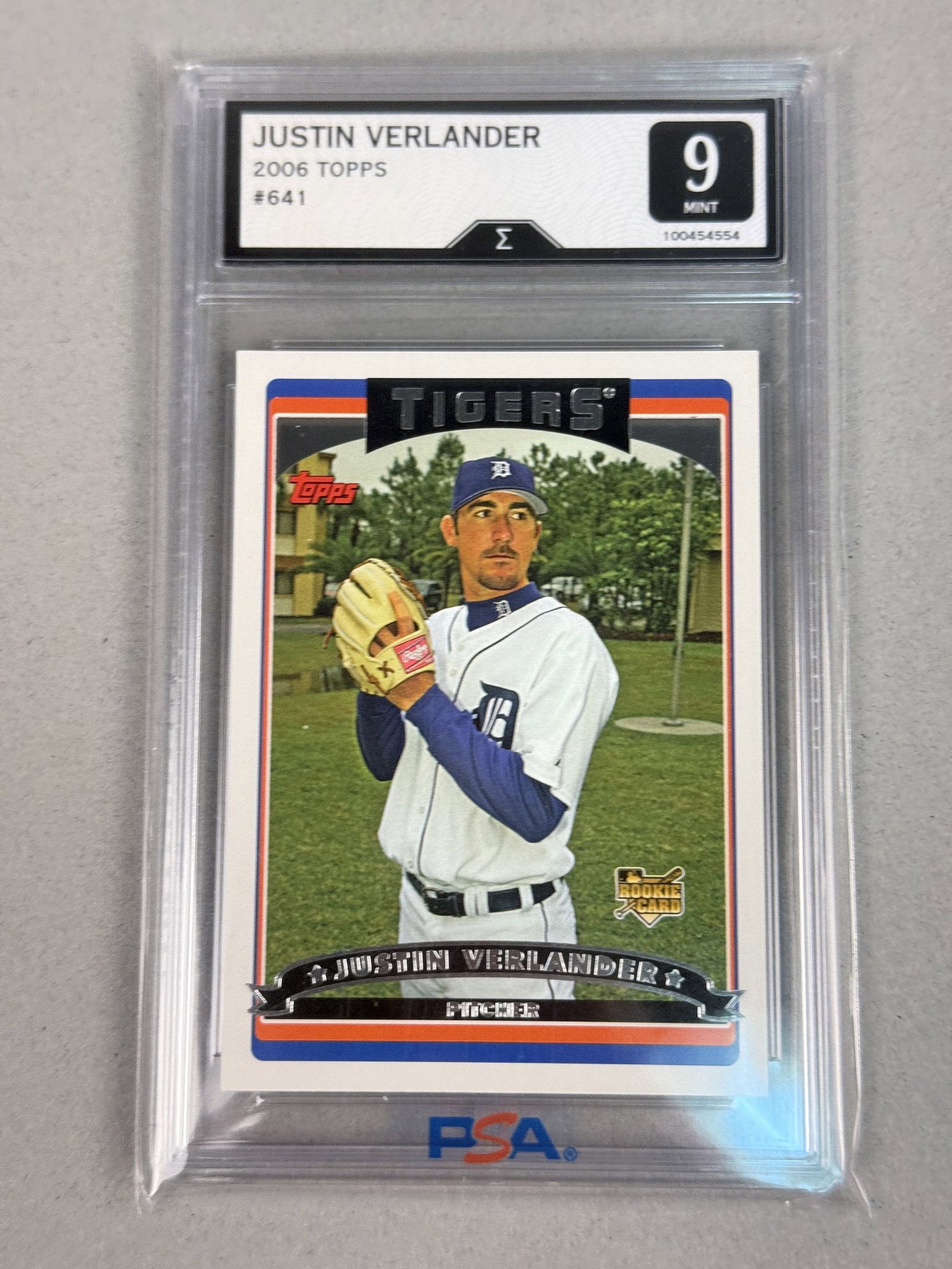 Topps Justin Verlander #641 Sigma 9 Card: This 2006 Topps Justin Verlander rookie card, number 641, features the pitcher in his Detroit Tigers home uniform. The card front bears a red and orange Topps brand logo in the upper left corner and a