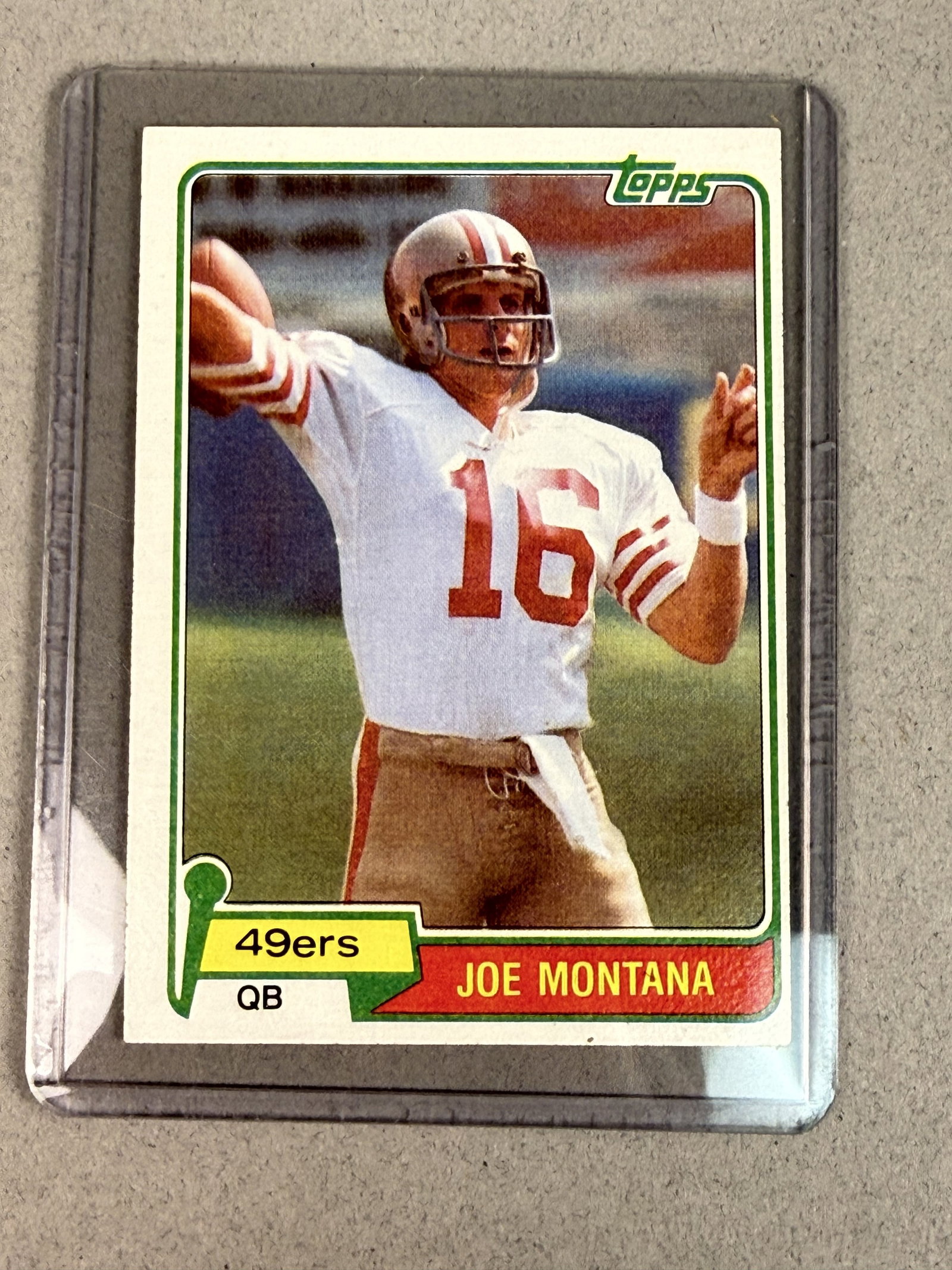 1981 Topps Joe Montana Rookie Card 216: A 1981 Topps football card, number 216, featuring San Francisco 49ers quarterback Joe Montana. This is the official rookie card for the Hall of Fame athlete, showing him in a passing motion wearing a 