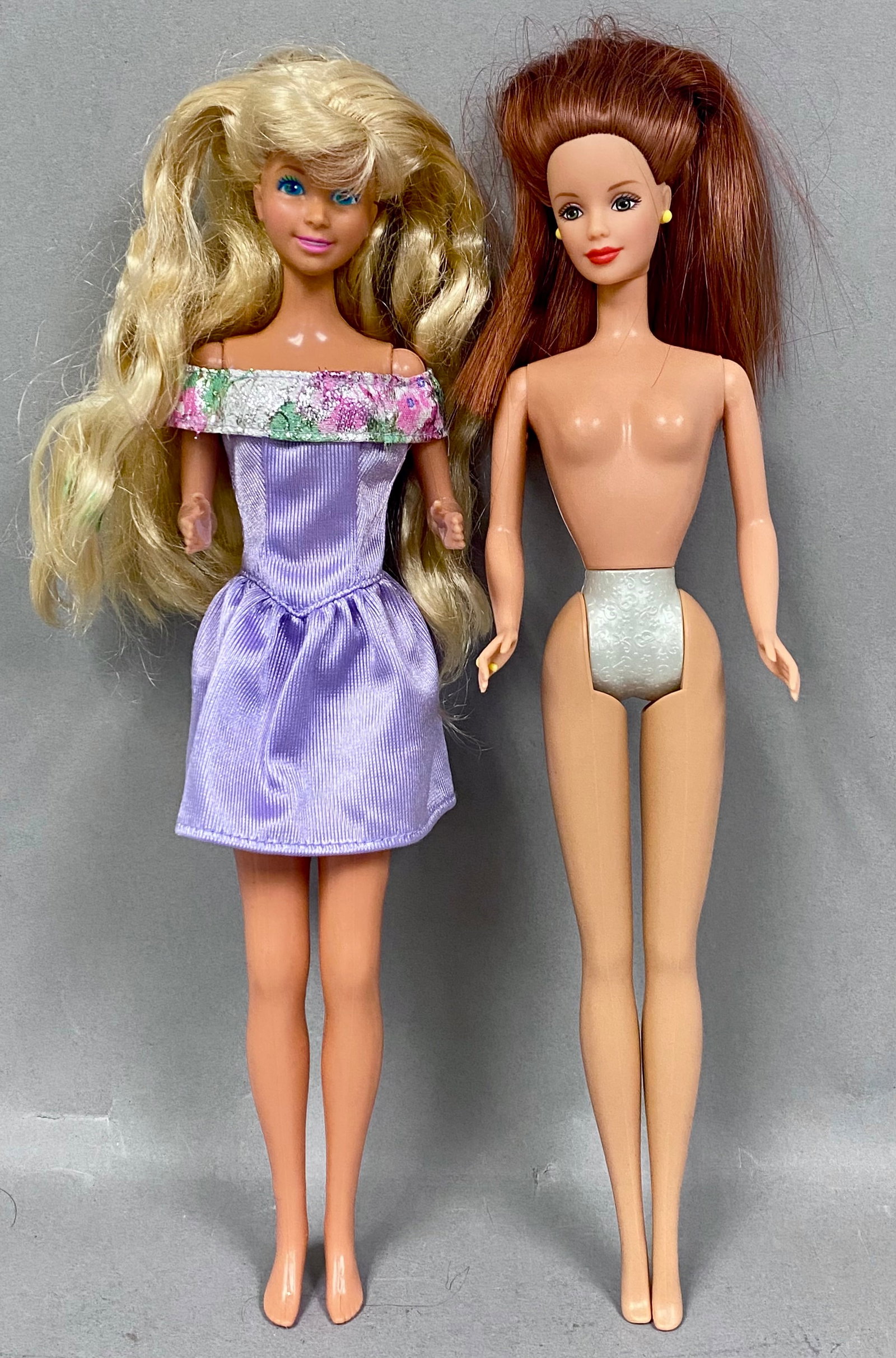 2 Mattel Vinyl Fashion Dolls: An assortment of two Mattel fashion dolls constructed with vinyl bodies and rooted synthetic hair. The first doll features a tanned skin tone with blonde hair styled in a high ponytail and painted blu