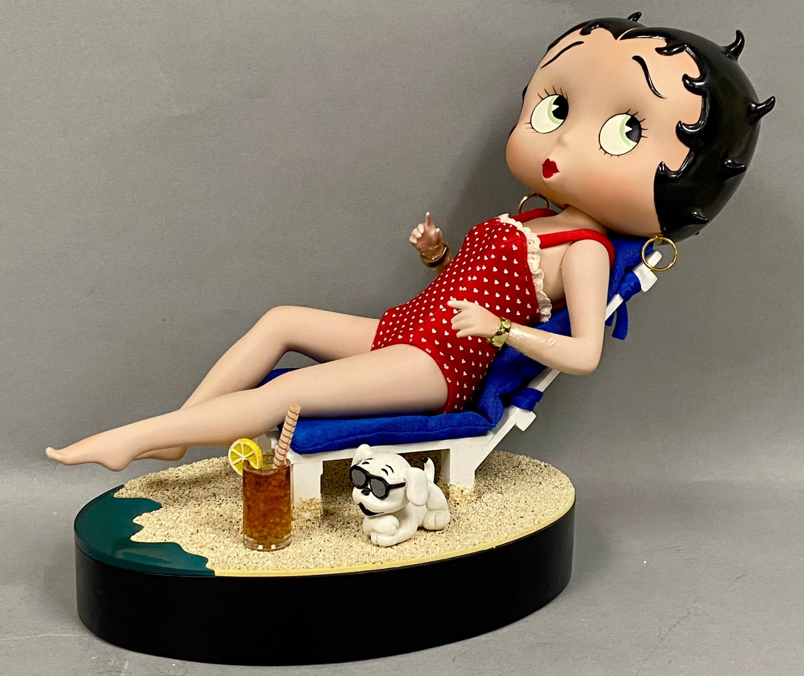 Danbury Mint Syd Hap Betty Boop Bathing Beauty: A licensed Betty Boop collector doll ensemble titled Bathing Beauty, designed by artist Syd Hap for Danbury Mint. The hand-painted figure is depicted reclining in a white wooden-style beach chair
