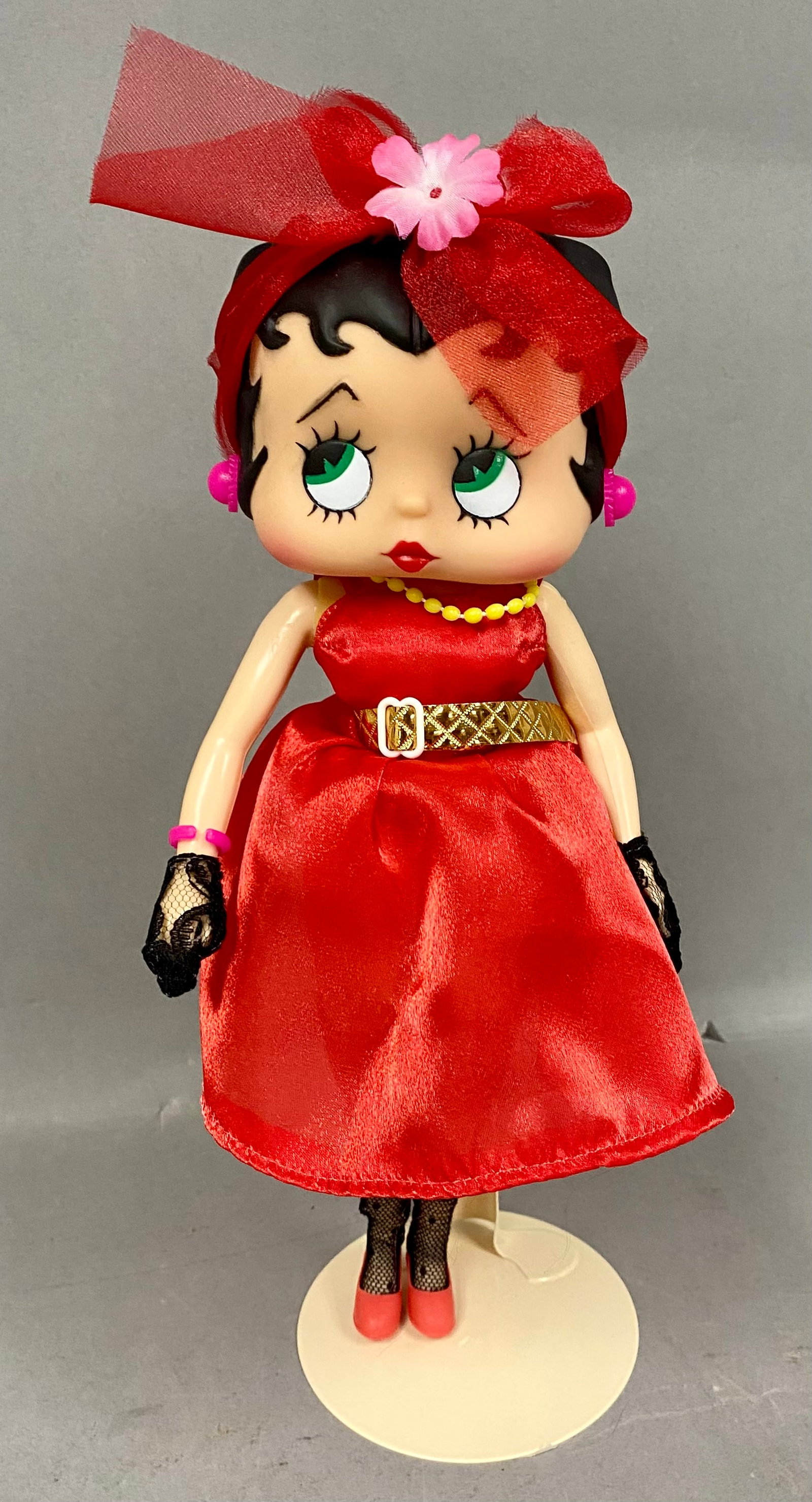 Marty Toy 1986 Betty Boop Fashion Doll: A vintage vinyl Betty Boop fashion doll manufactured by Marty Toy in 1986. The doll features a jointed body with a movable neck, shoulders, and hips. Her head is designed with molded black hair in sig