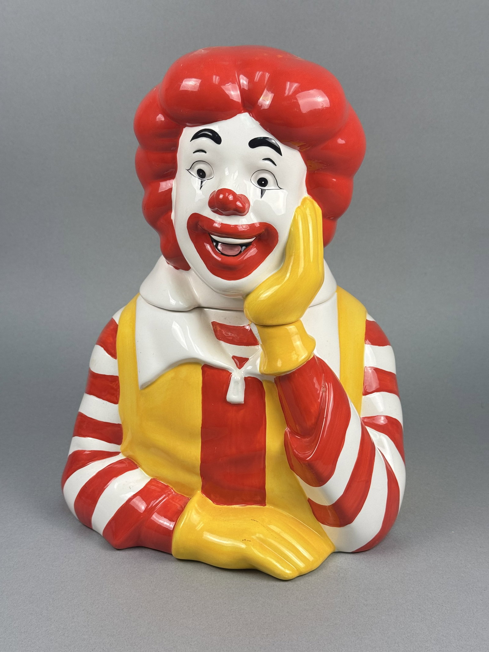 Treasure Craft Ceramic Ronald McDonald Cookie Jar: A large glazed ceramic cookie jar featuring a bust-length figure of the iconic fast-food mascot Ronald McDonald. Produced by Treasure Craft. The underside of the jar features an incised mark that