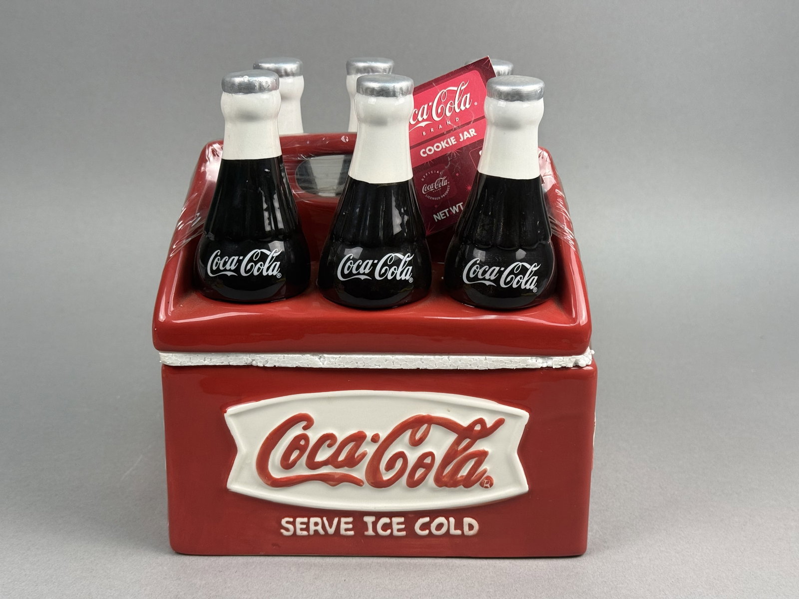 Houston Harvest Ceramic Coca-Cola 6-Pack Cookie Jar: This officially licensed Coca-Cola ceramic cookie jar is designed in the form of a classic red six-bottle carrier. The piece retains its original red paper hangtag which identifies it as a Coca-Cola