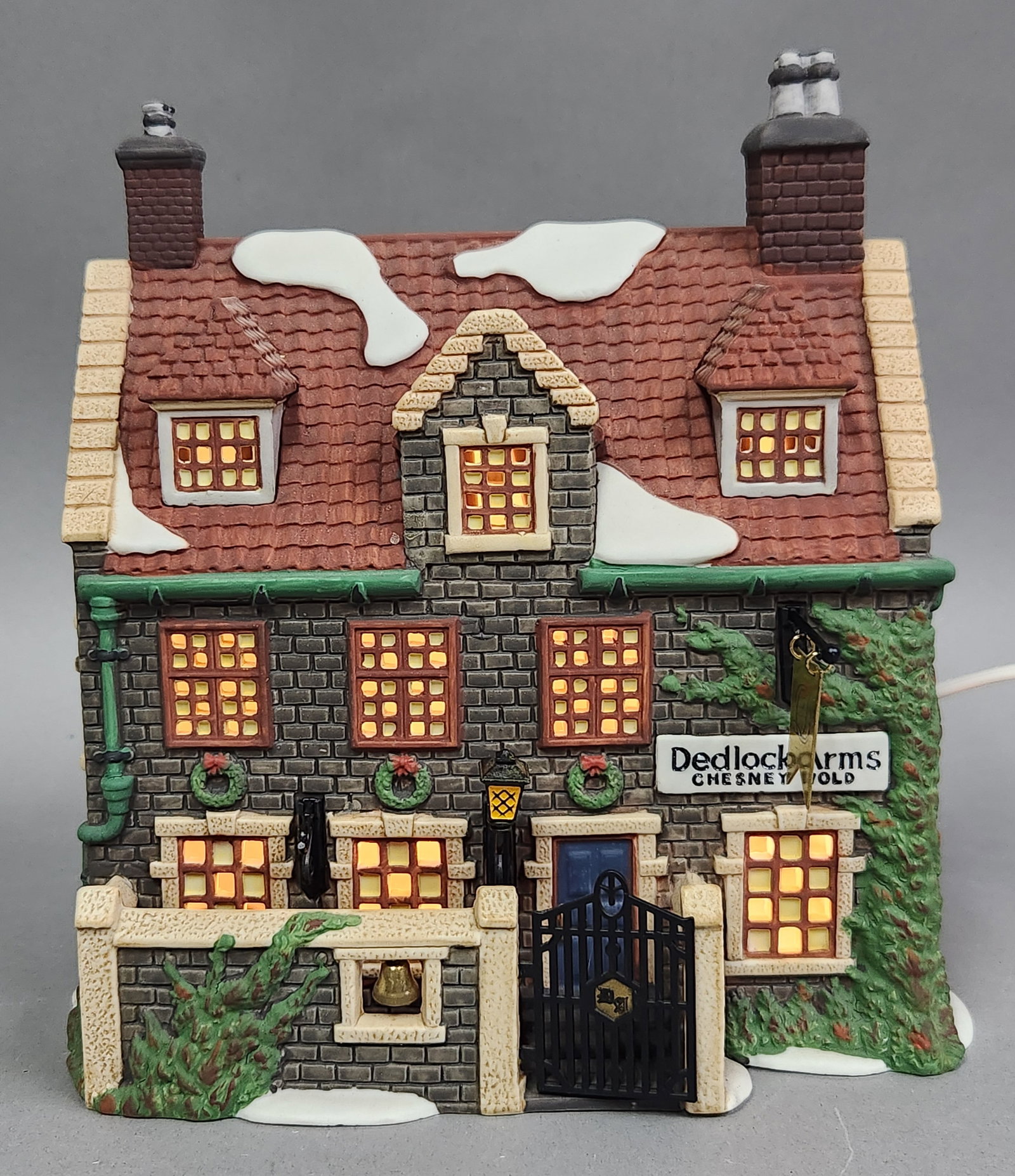 Department 56 Dedlock Arms: This hand-painted porcelain lighted miniature building is titled Dedlock Arms and is part of the Dickens Village Series by Department 56. The base of the building is printed in gold and reads DICKENS 