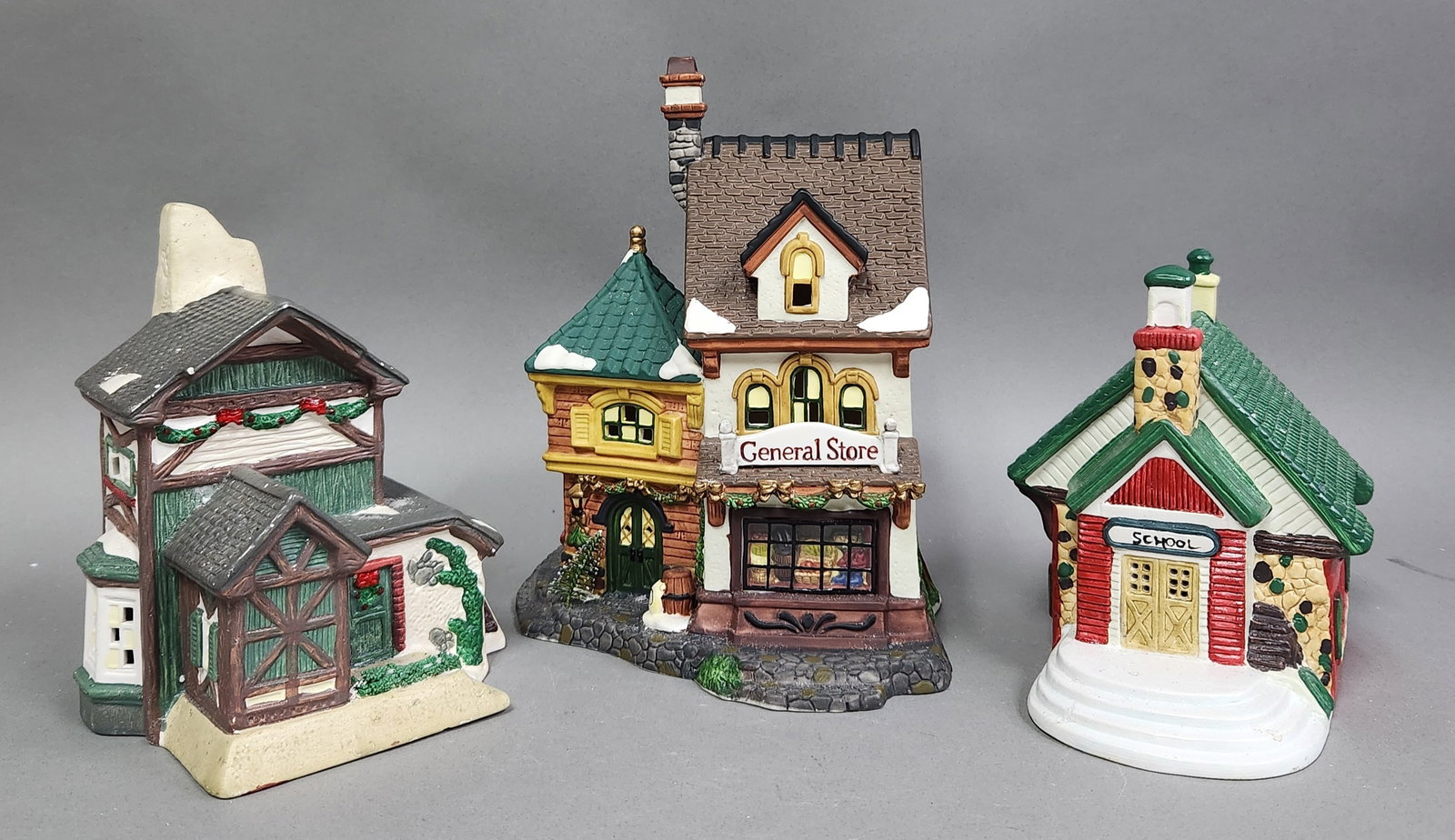 O'Well & Our Town Christmas Buildings: Three porcelain Christmas village buildings including a multi-story General Store from the O'Well Heartland Valley Village series. Original manufacturer boxes are included for the O'Well and Our Town