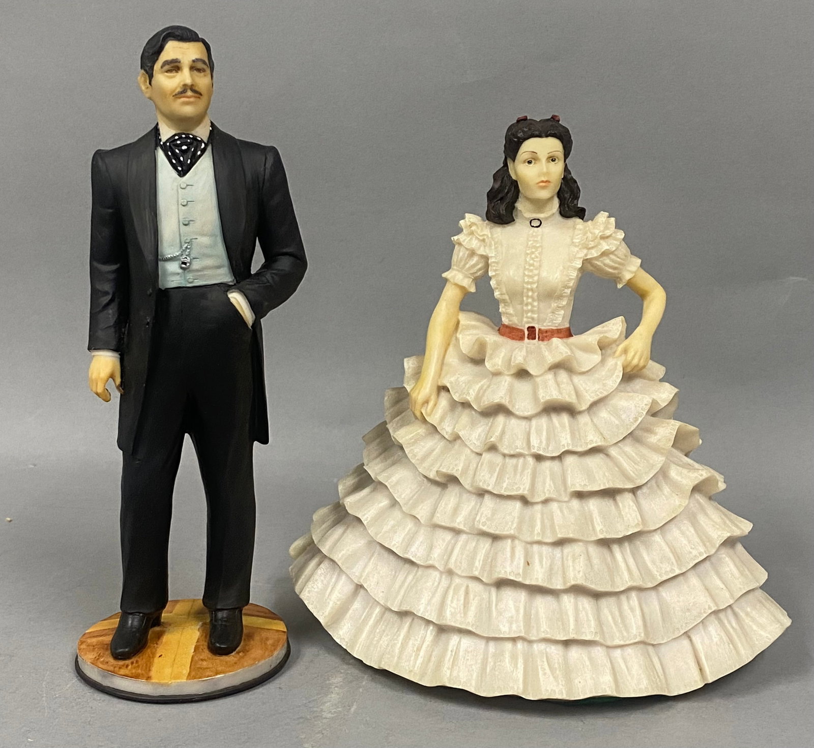 Dave Grossman Gone With The Wind Figurines: A pair of hand-painted cold cast marble figurines from Dave Grossman Creations depicting Rhett Butler and Scarlett O'Hara from the 1939 film Gone With The Wind. The Rhett Butler figure is modeled as a