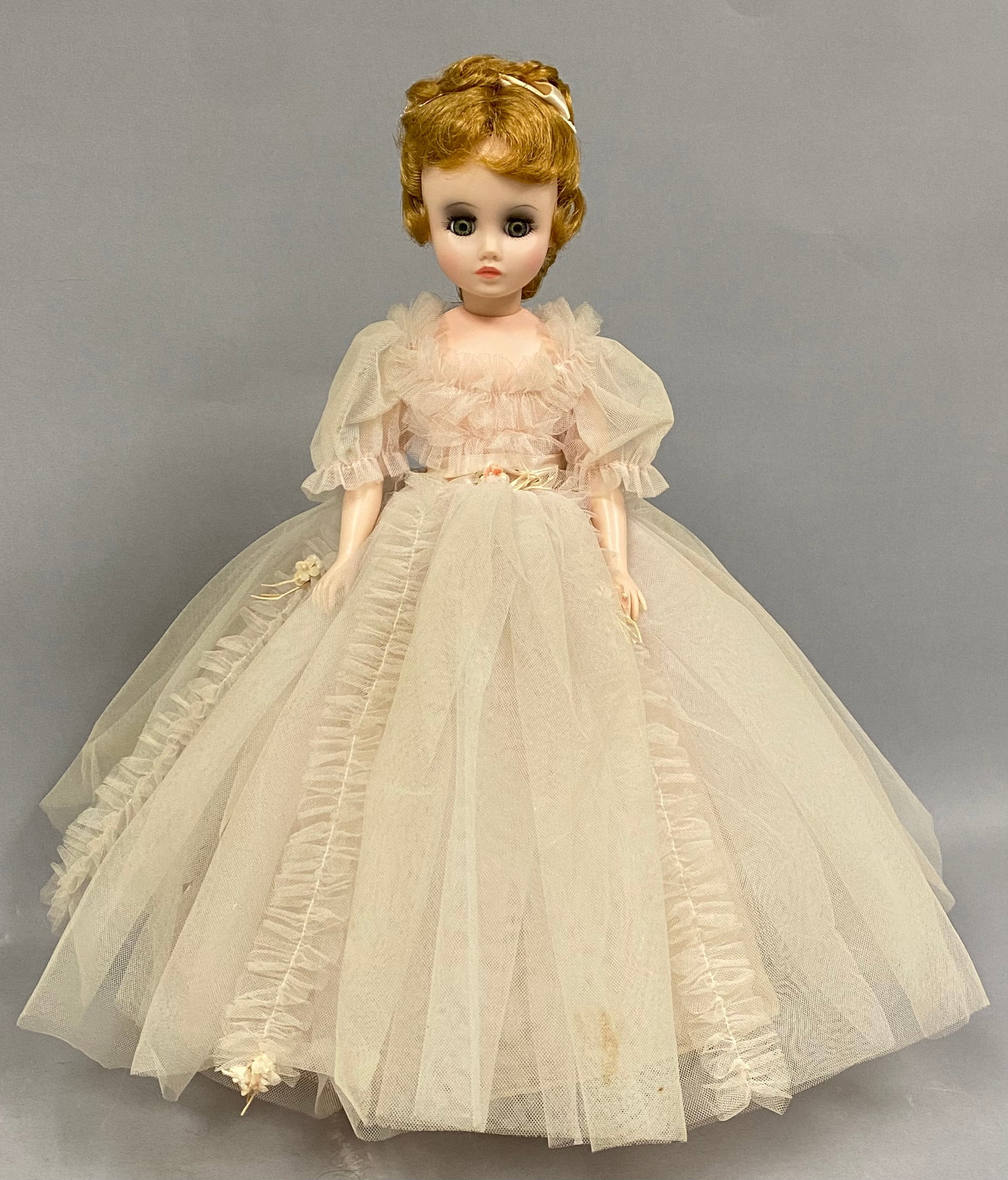 Madame Alexander Elise Pink Tulle Doll: This vintage Madame Alexander Elise doll features a hard plastic jointed body and a vinyl head with rooted reddish-blonde hair in an updo style. She possesses green sleep eyes with molded eyelashes an