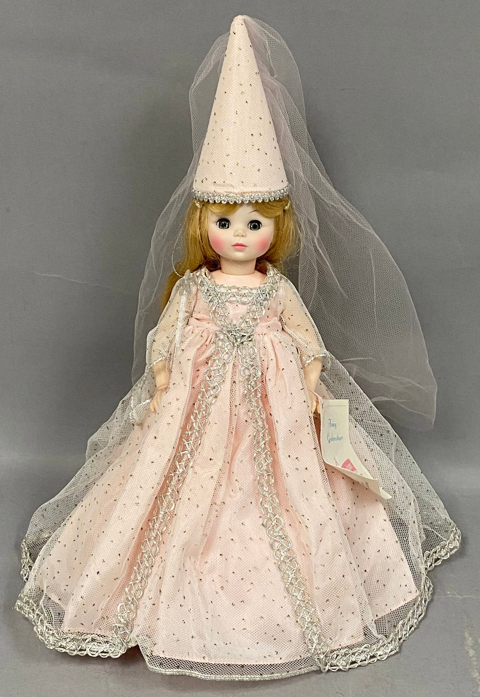 Madame Alexander Fairy Godmother Doll: This vintage Madame Alexander doll depicts the character of the Fairy Godmother. The doll features a hard plastic and vinyl construction with a blonde synthetic wig styled in soft ringlets and blue