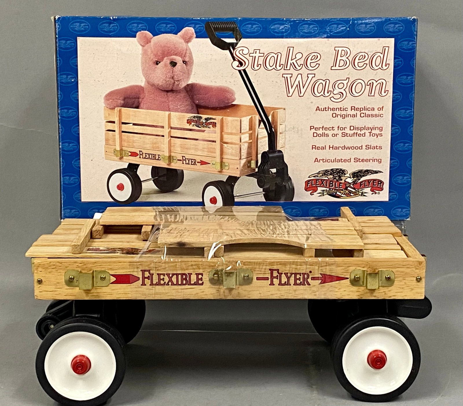 Flexible Flyer Hardwood Stake Bed Wagon: A miniature replica stake bed wagon produced under the Flexible Flyer brand. The model is constructed with real hardwood slats and features articulated front steering with a black steel handle shaft.