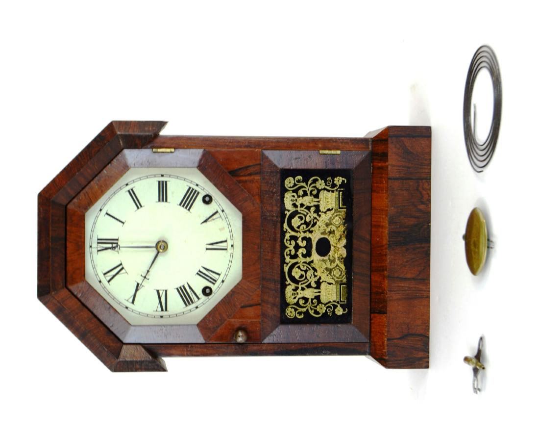 Seth Thomas Rosewood Clock: This “Made and Sold by Seth Thomas, Plymouth Hollow, Connecticut brass 8 day clock” is beautifully appointed with its original gold leaf reverse paint on glass, painted metal face, and desired S M