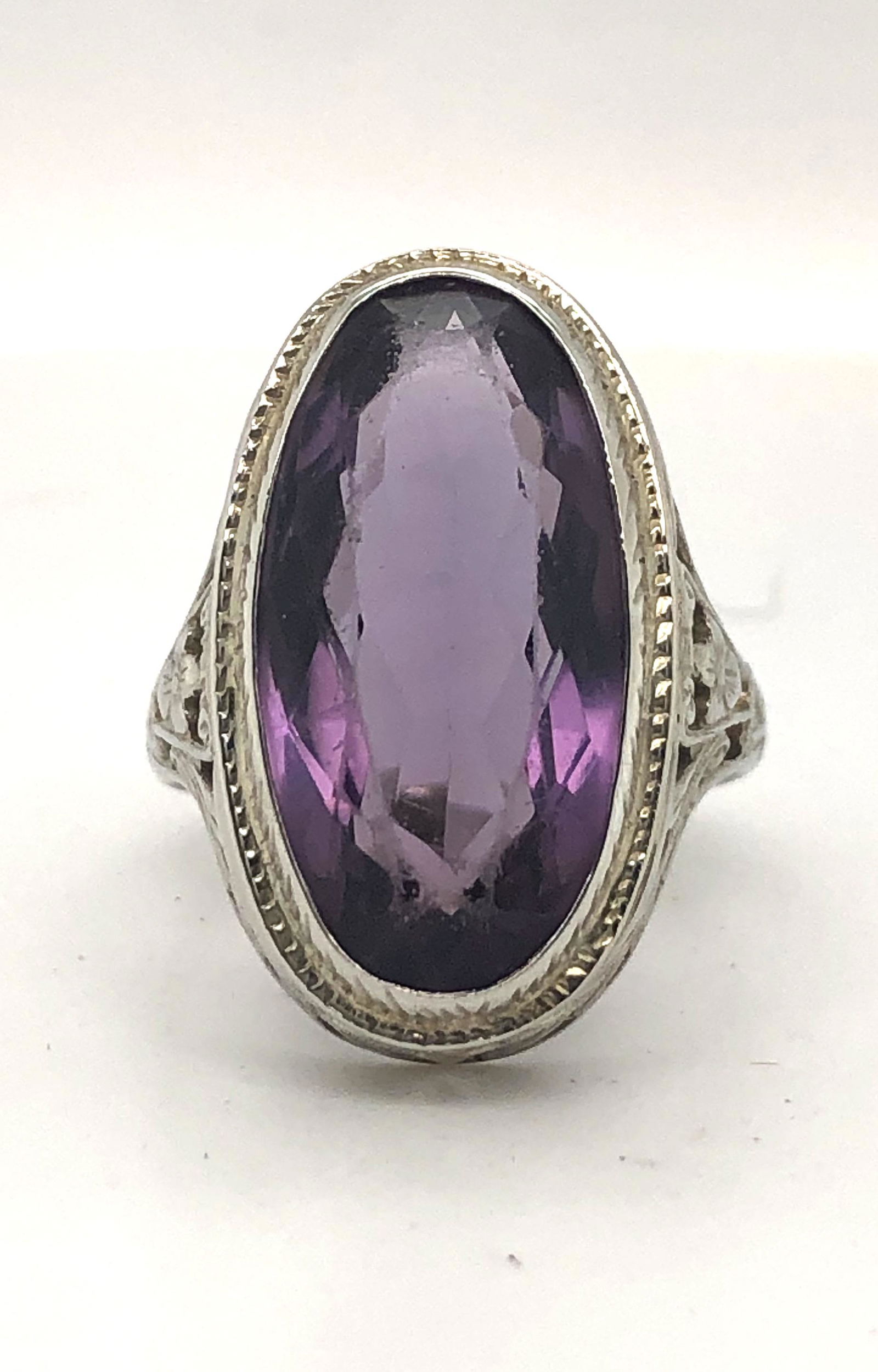Amethyst Ring: Vintage 18 karat white gold Amethyst ring with filigree design. Oval Amethyst measures approximately 19.0 x 9.2mm bezel. Size 6 ¼, can be sized. Ring weighs 5.7 grams. Marked and tested.