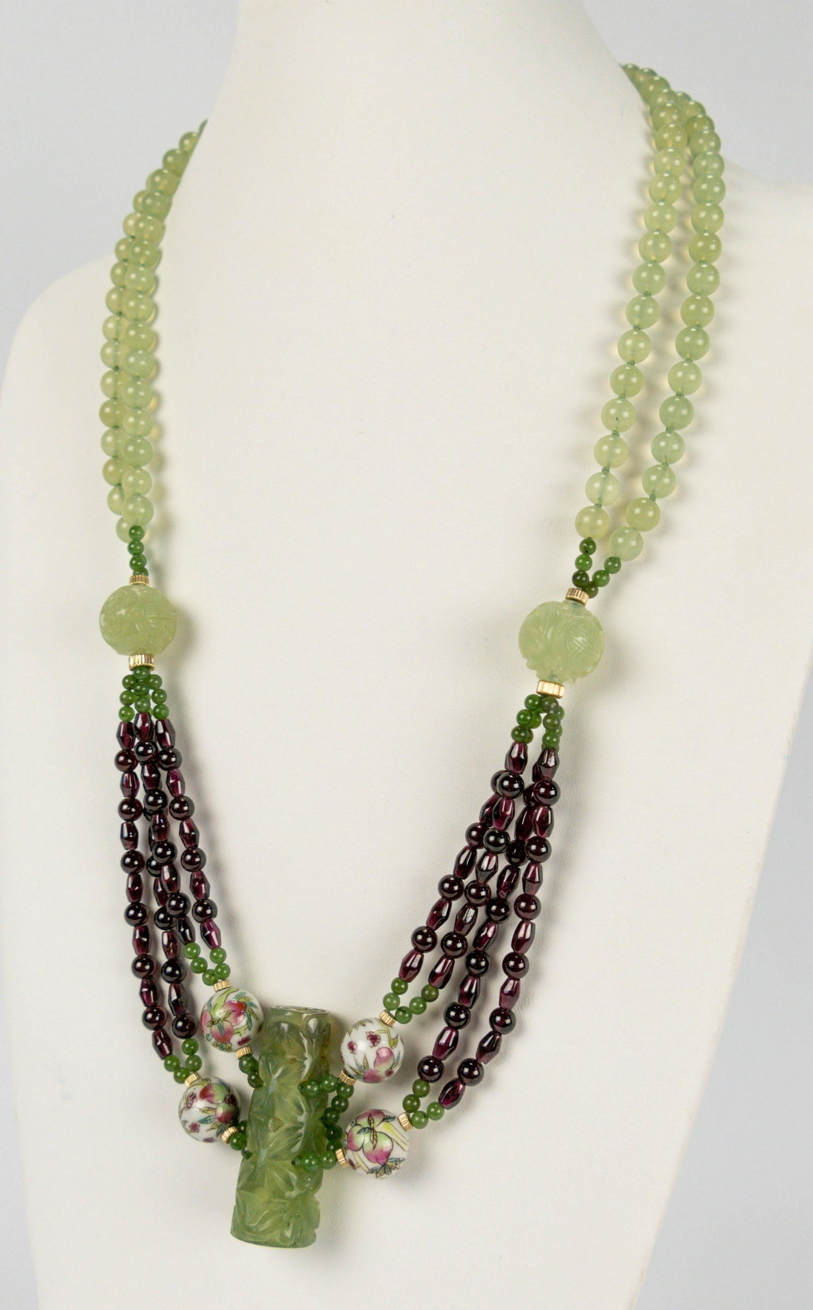 Carved Jade Garnet Porcelain Bead Pendant Necklace: 20thC. Excellent condition throughout. 29" necklace with a gold filled clasp and beads features carved jade and sepentine beads and pendant, along with natural polished garnets and hand painted porcel