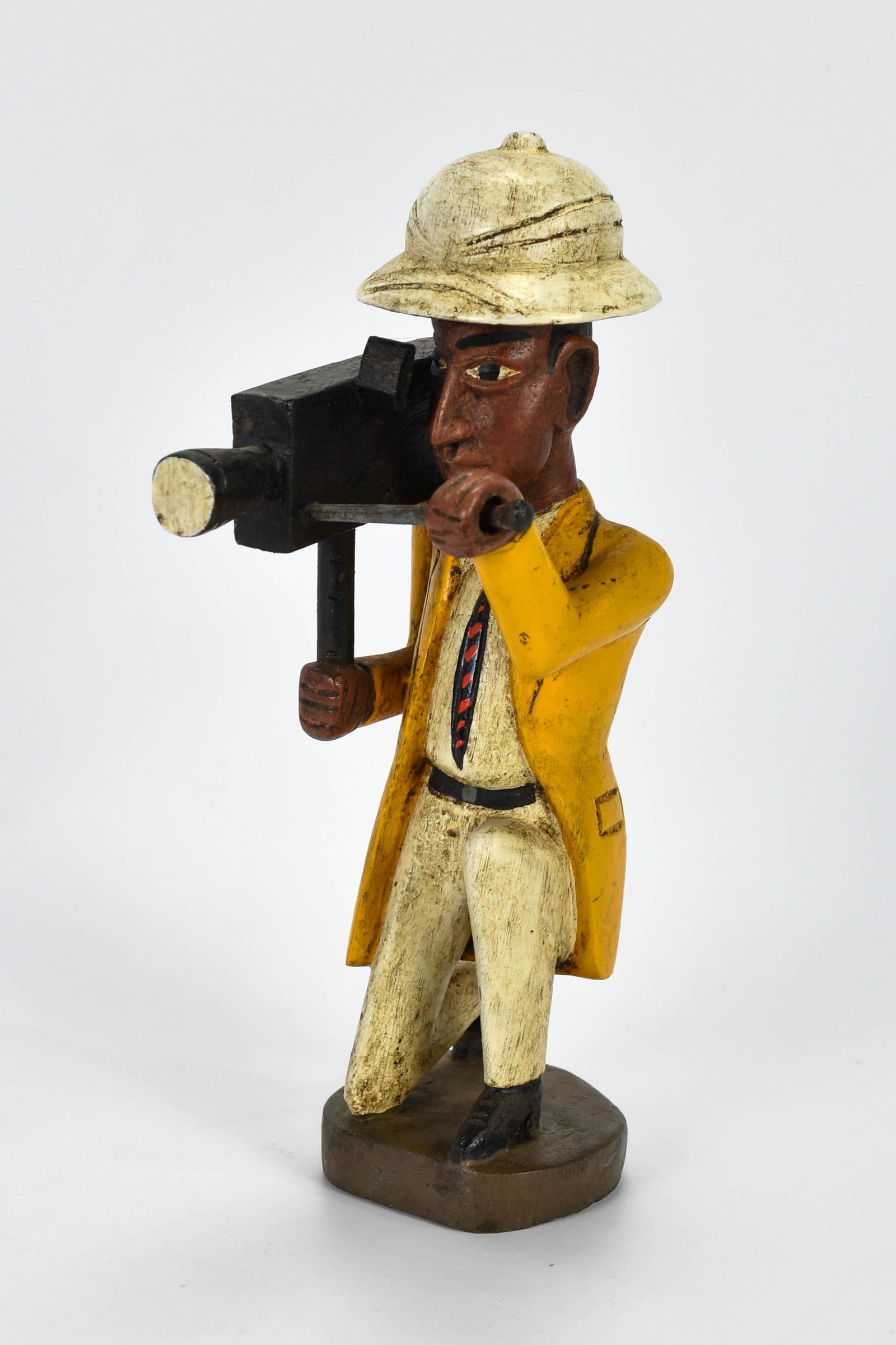 Nigerian Colonial Carved Painted Wood TV Cameraman: Second half 20thC. Excellent original condition throughout, including the polychrome paint. Not large at about 12" tall, this is a charming figurine well carved and painted.