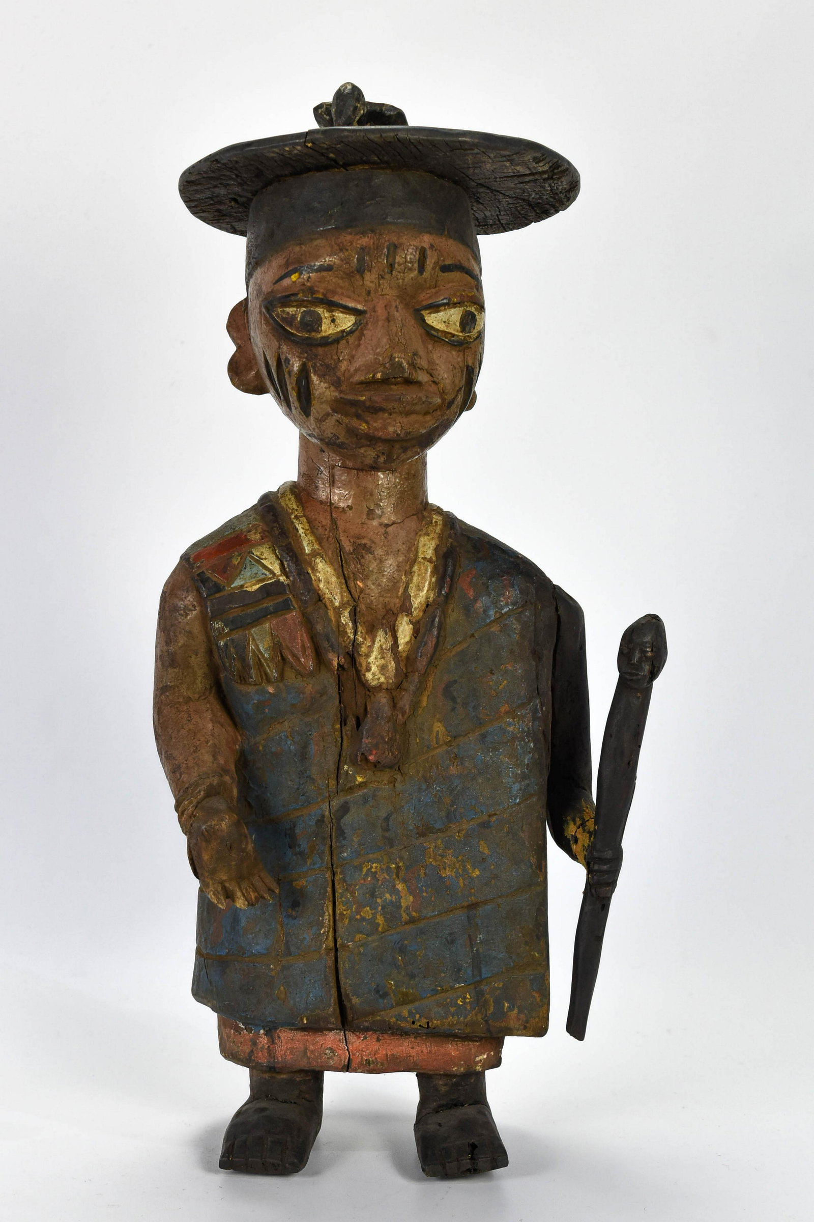 Old Carved Painted Wood Yoruba Male Priest Statue: 2nd-3rd quarter 20thC. Standing male with left hand holding face staff. Has some wood erosion and beetle holes (not active), with a repaired left arm and hand. Holes drilled through feet show possible