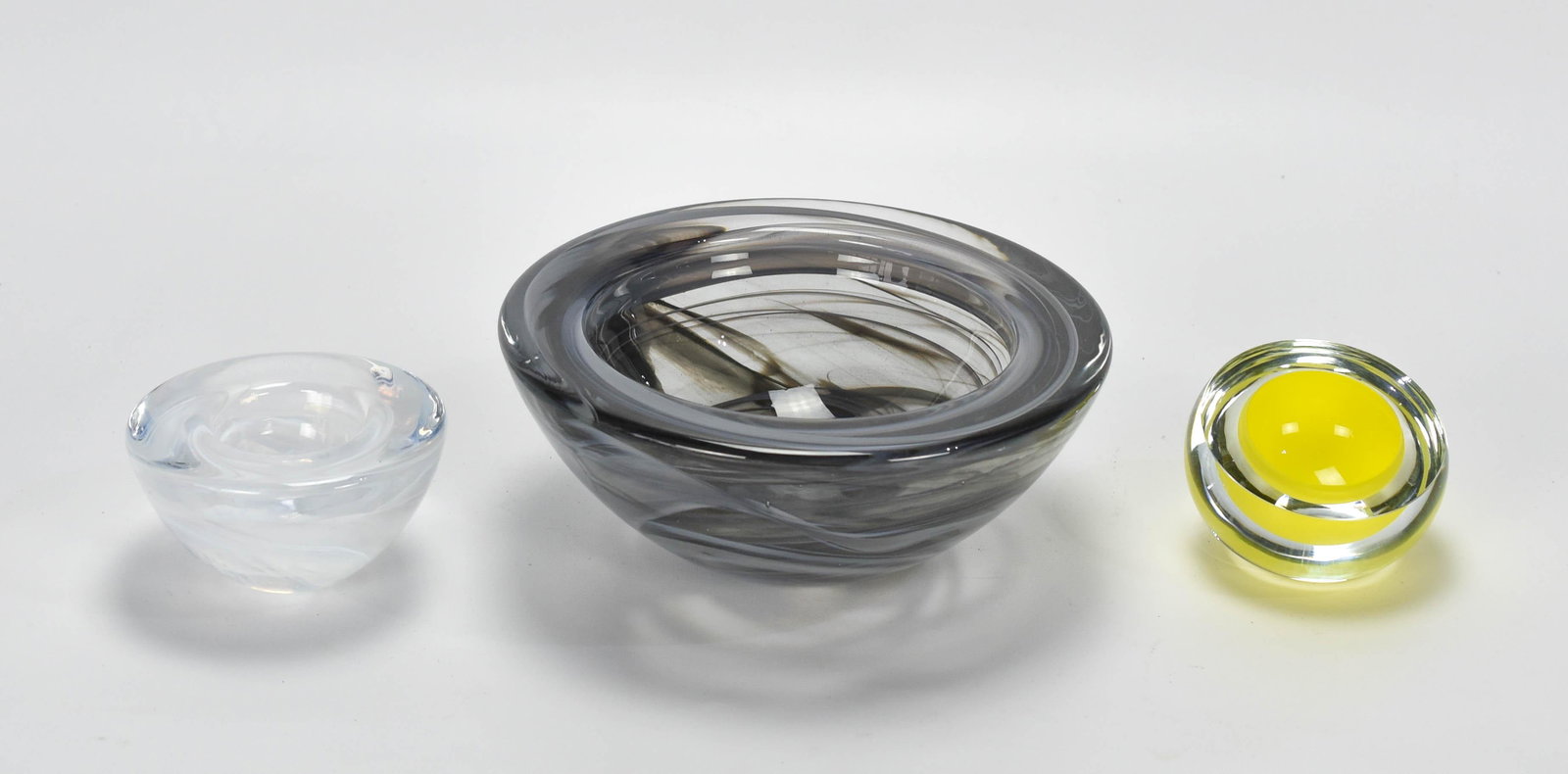 Anna Torfs & Kosta Boda Geode Art Glass Bowl Set: The yellow cased bowl is signed Anna Torfs, 2003. The largest bowl is marked Kosta Boda. The middle bowl is unmarked but likely is also Kosta Boda. All three free of chips, cracks, scratches or repair