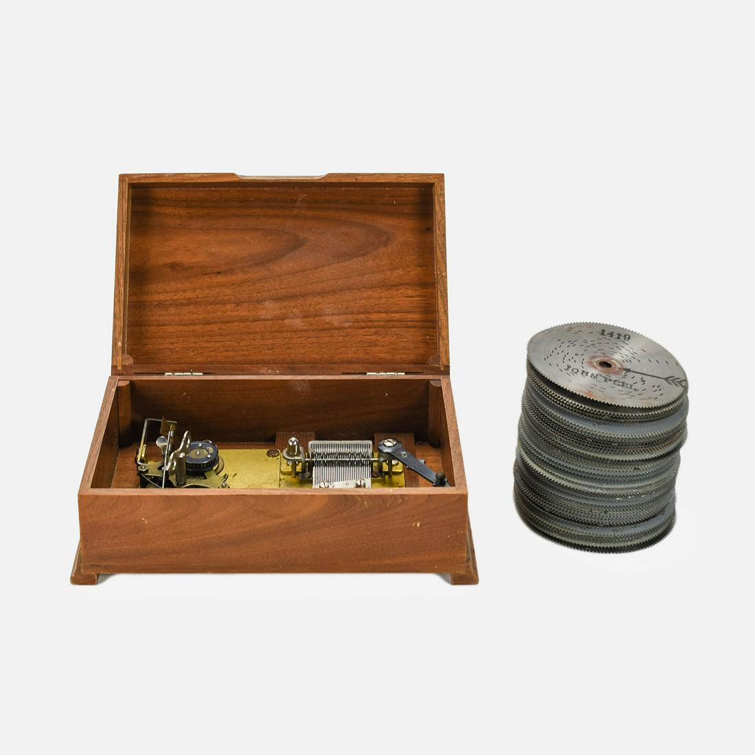 Small Swiss Disc Music Box w/51 Discs: Ca. Mid 20thC. Working condition with no broken teeth. Should be cleaned and oiled for best operations. 31 teeth. Wooden case has superficial scuffs.