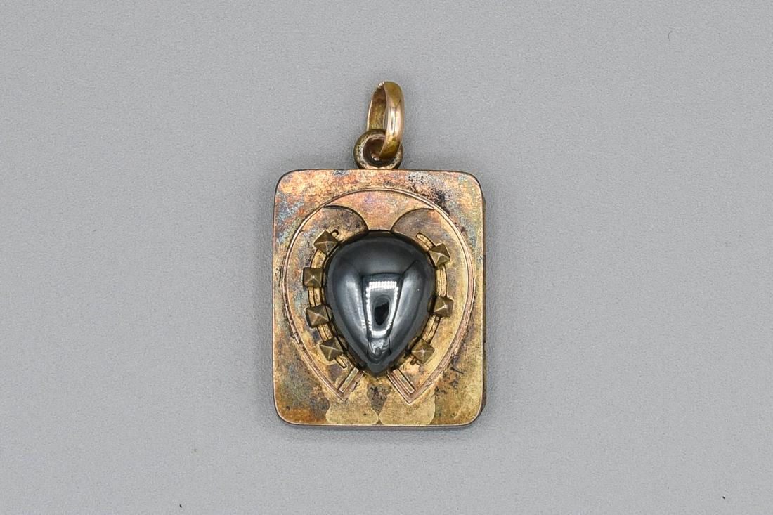 Antique 14K Yellow Gold Hematite Locket Pendant: Ca. last half 19thC to first quarter 20thC. Has scratches on the interior where the attached mount is bolted together. Overall wear with small dings and scratches. 20 Grams includes the stone. We figu