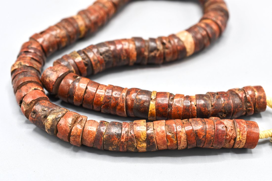 Rough Cut Red Stone Disc Bead String: 20thC. Very good with age appropriate wear including small dings throughout. At first glance these appear to be coral, however, looking through a 10X loupe no grain is evident, so we assume these are 