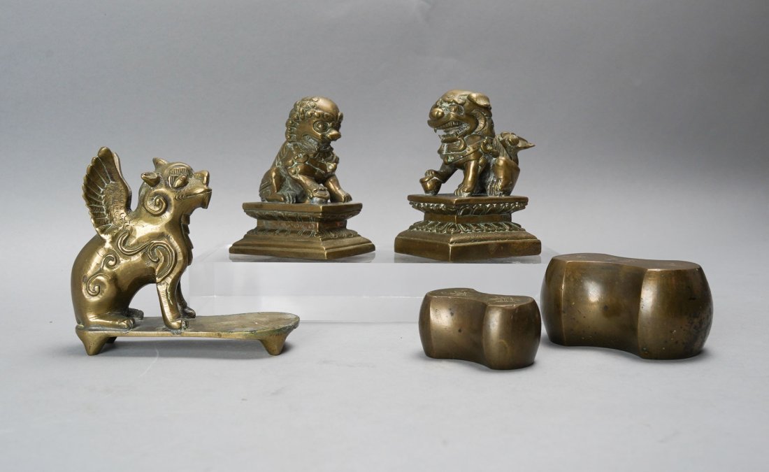 Two Antique Chinese Bronze Opium Weights plus Fu Dog Pair: Group of 5 brass/bronze pieces. Winged weight measures approx. H: 4" W: 4 1/2" D: 2". Smallest weight measures approx. 2 1/2" by 1 1/2".