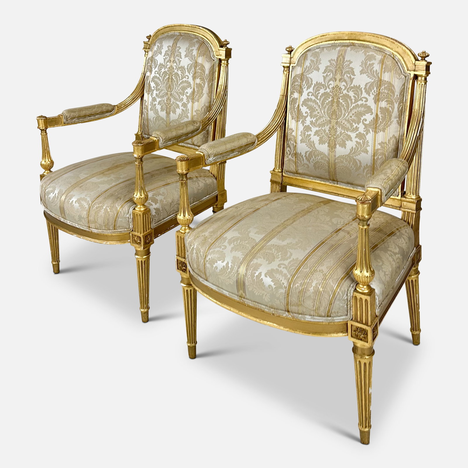 Two Antique 18th/19thC French Louis XVI Style Carved Giltwood Armchairs: Two Antique 18th/19thC French Louis XVI Style Carved Giltwood Armchairs. Ca. last quarter 18th to first quarter 19thC. Pinned construction. Very good with no apparent breaks or repairs. Fabric shows w
