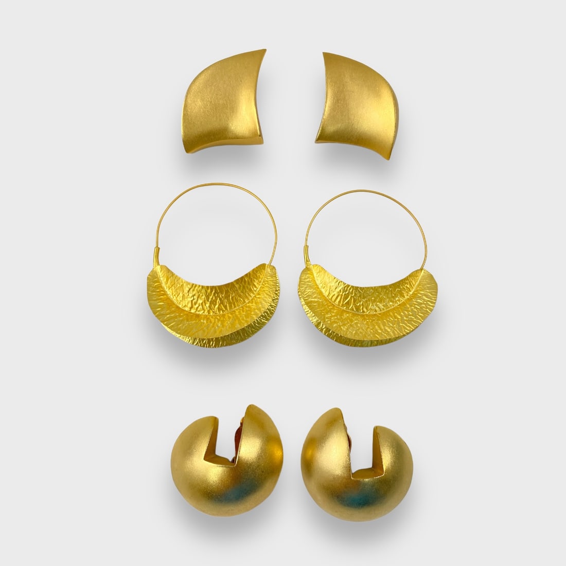 Three Pairs Lee Wolfe Gold Toned Modernist Earrings: Top & bottom are clip on. Middle pair is pierced. Largest approx 2 5/8”. Good preowned condition.