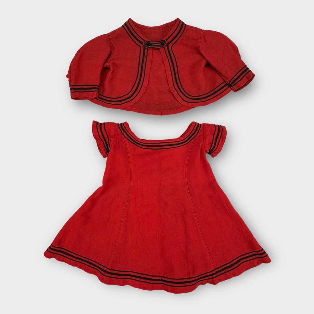 Vintage Red Cotton Childs Dress with Matching Jacket. Black Trim Details and Faceted Square Black: Jacket has holes in sleeves. Dress has small spot on front. Measurement taken flat. Shoulders 9.5 in. Chest 11 in. Shipping: We do not provide in-house shipping or packing. Please reach out to one of 