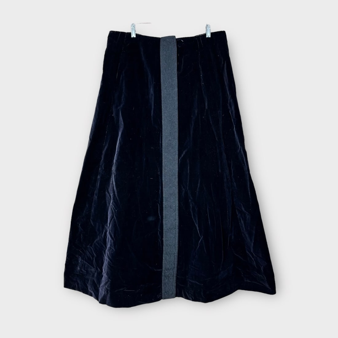 Antique Victorian Black Velvet Over Skirt with Knotwork Panels in Front and Back of Garment. No: Presenting some spots along hemline. Also tears in fabric from dry rot. Measurements taken flat. Waist 17 in. Length 43 in.